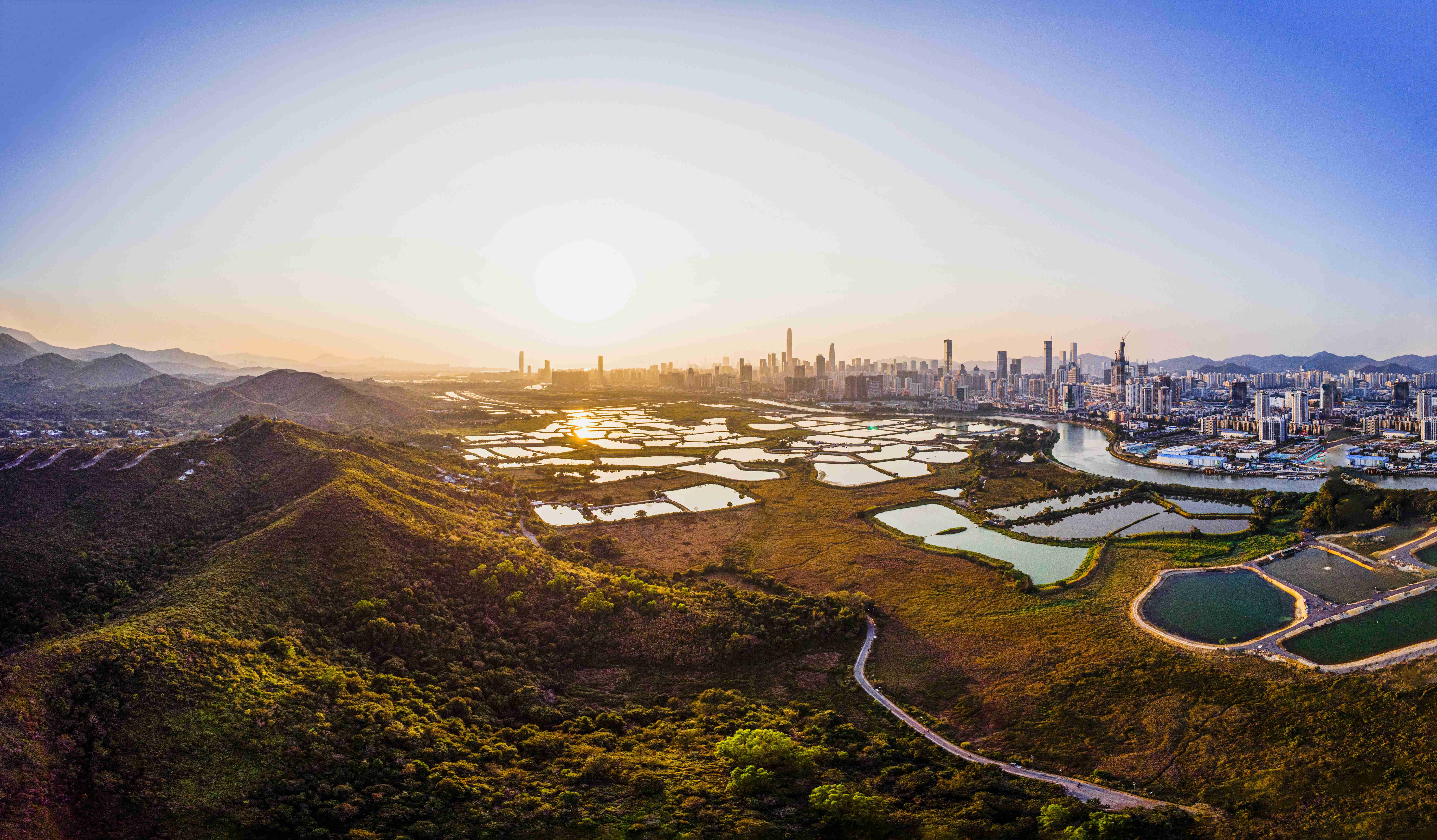 Aerial View of Cityscape at Sunset with Natural Landscape