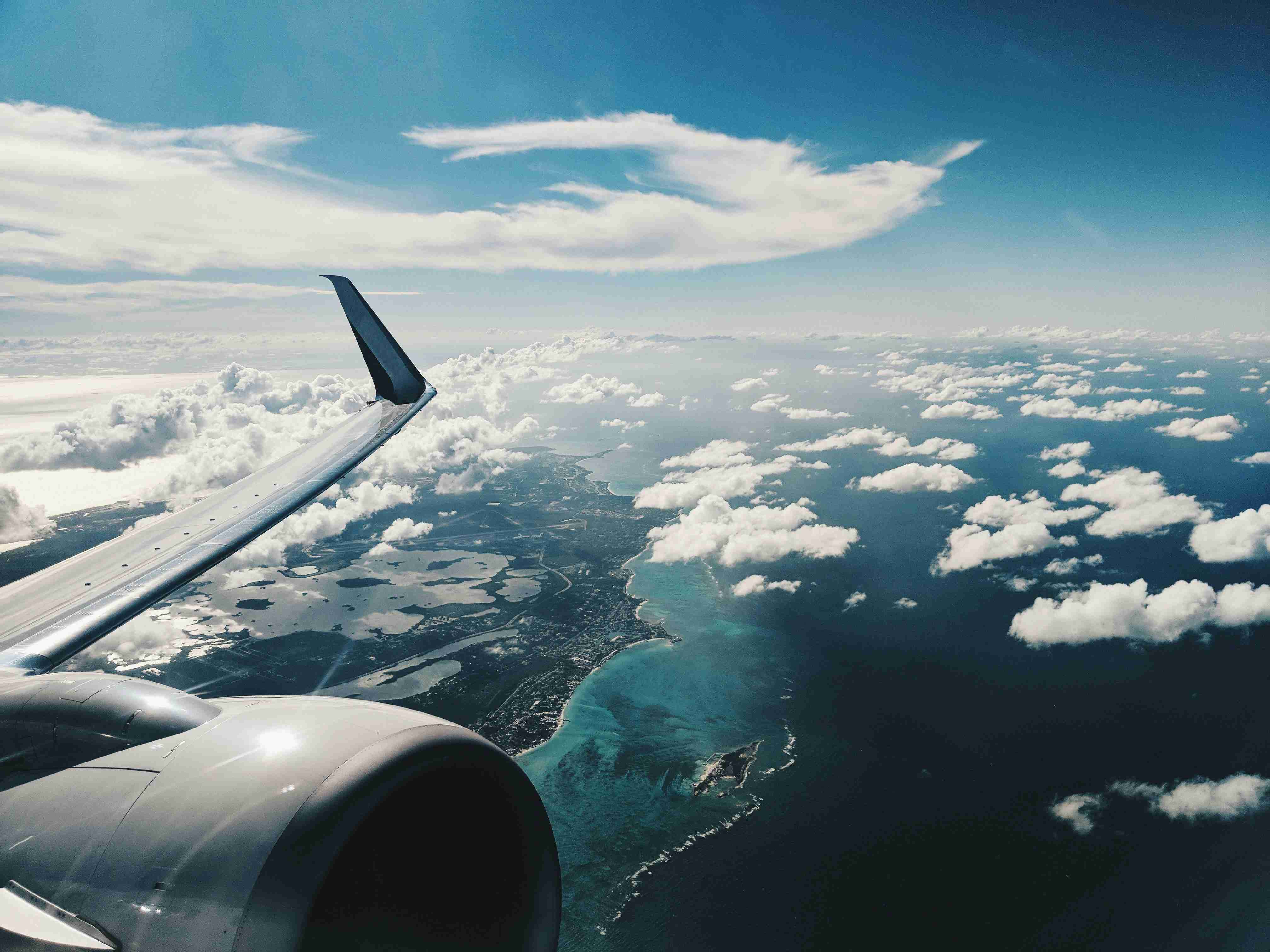 Aerial View of Clouds and Coastline from Airplane
