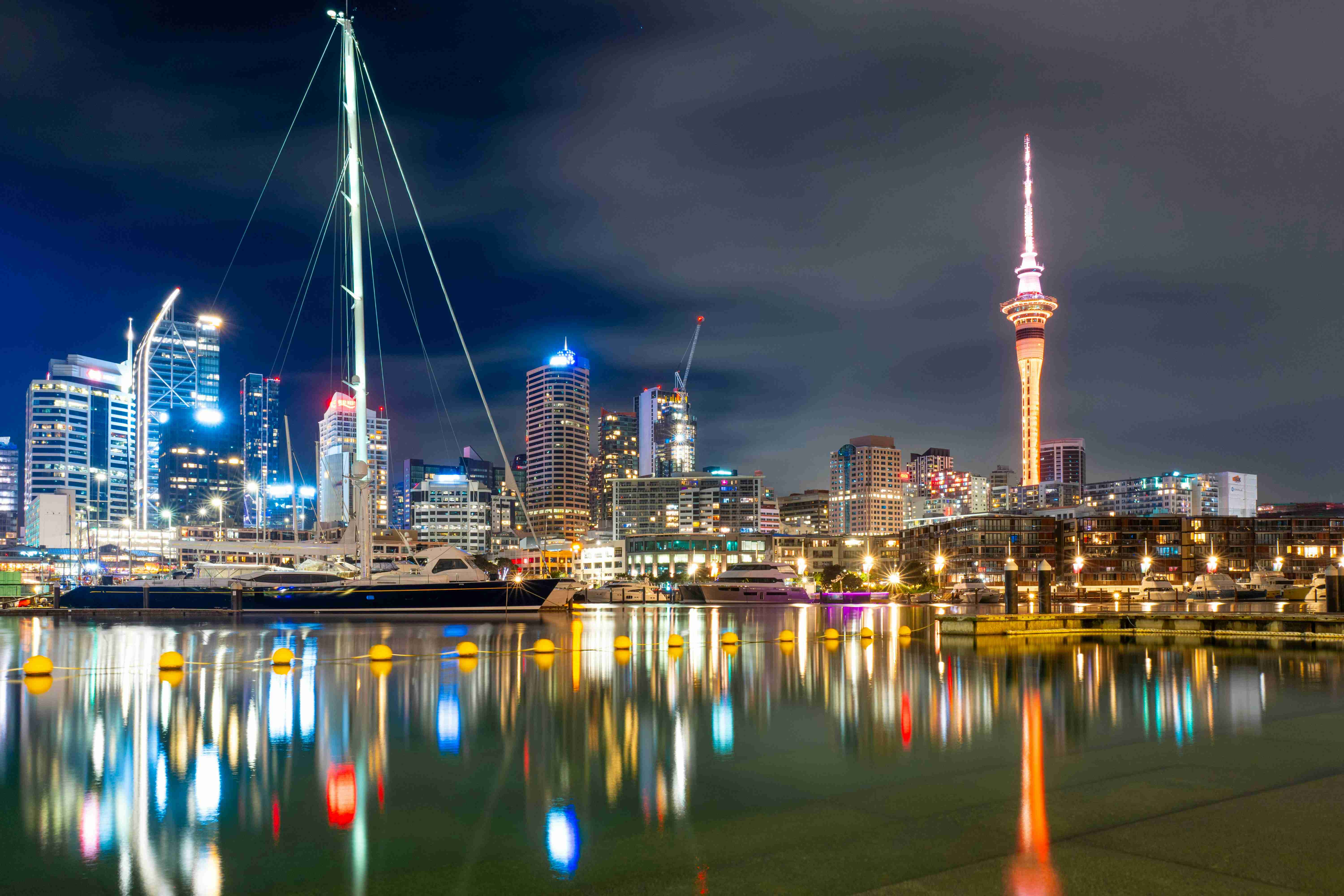 Puerto de Auckland de noche con iluminación de Sky Tower
