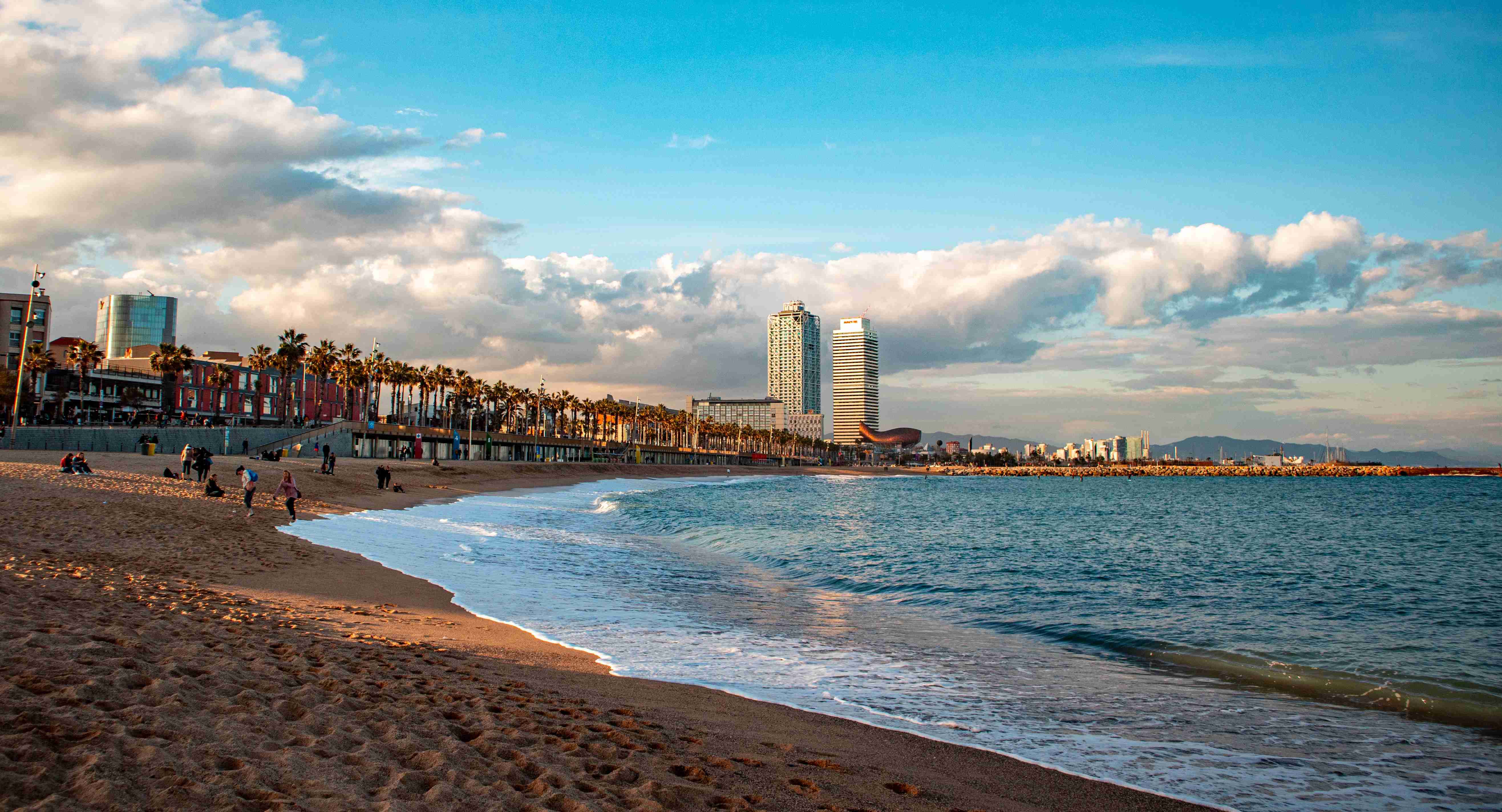 Pláž Barceloneta s panoramatem města a zataženou oblohou