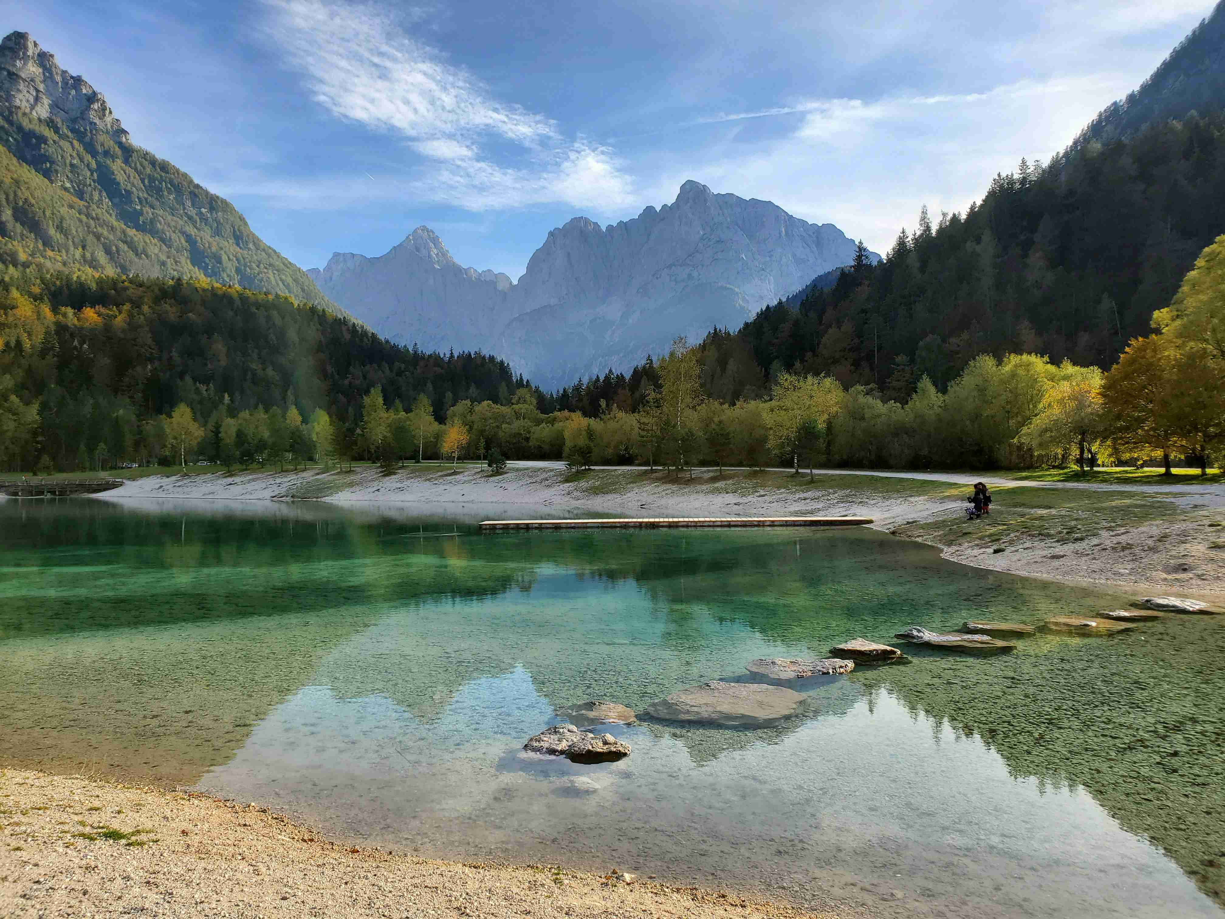 Crystal Clear Mountain Lake with Autumn Foliage and Rocky Peaks