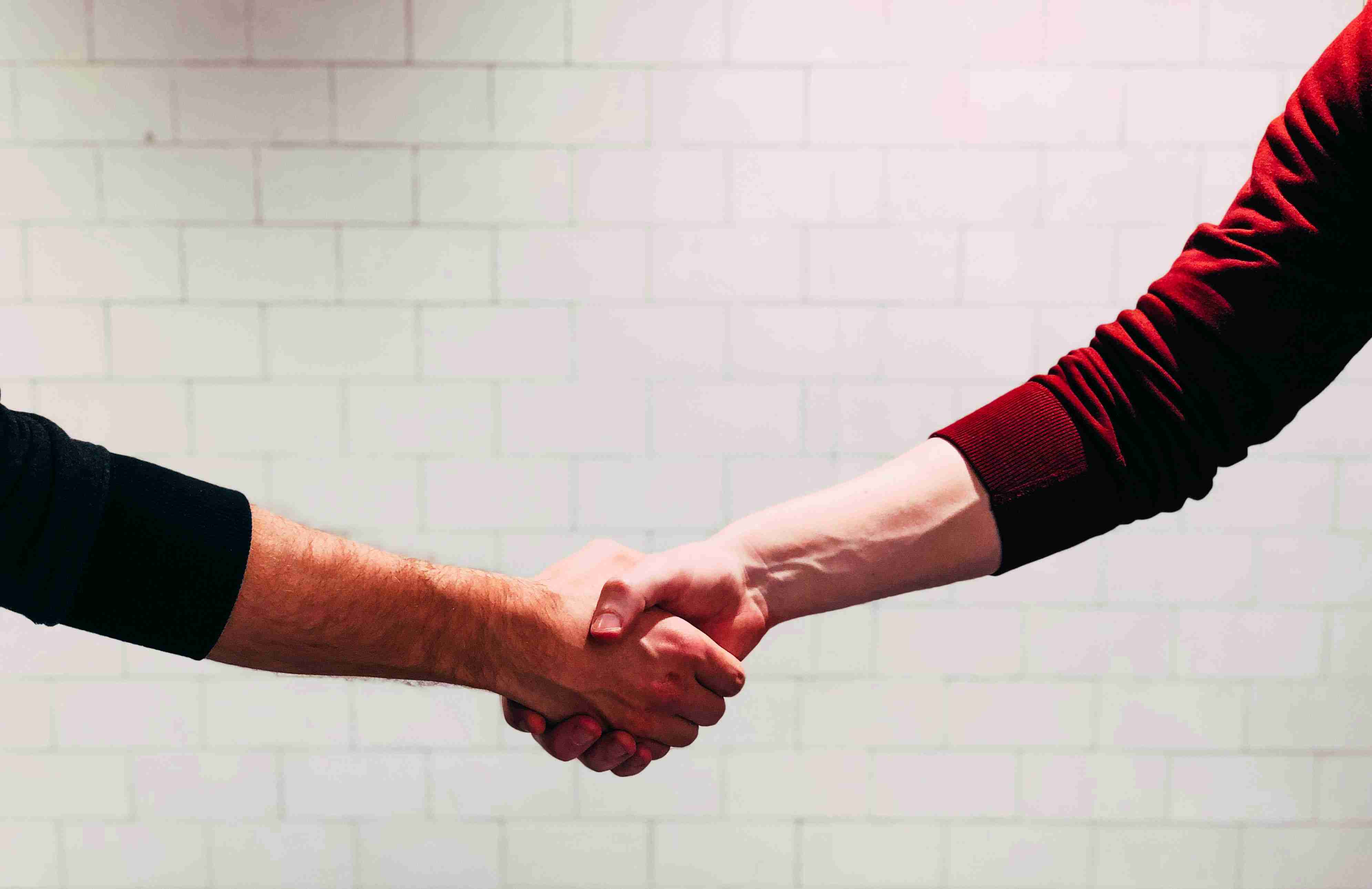 Handshake Agreement White Brick Background