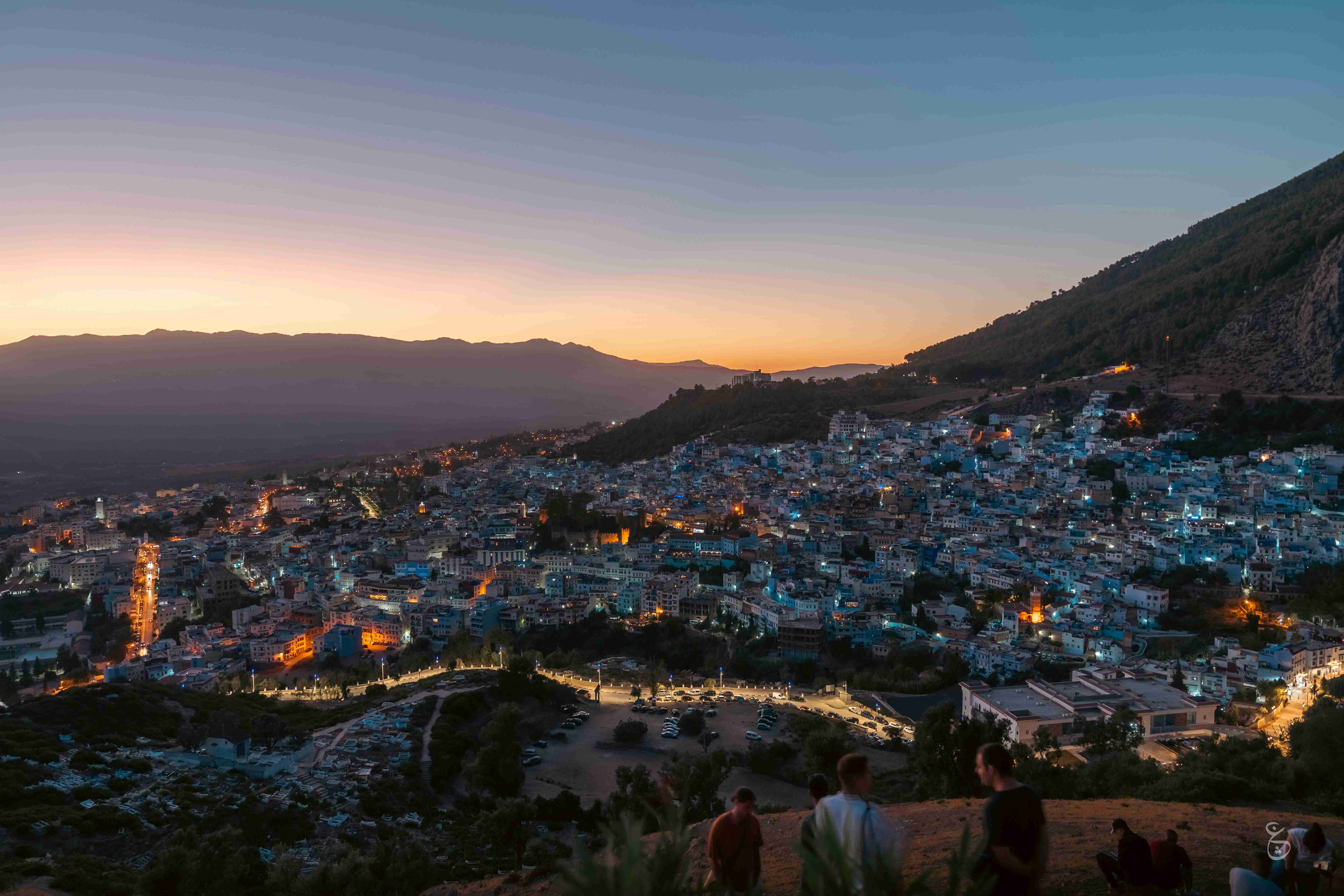 Hillside View of City at Dusk with Mountain Silhouette