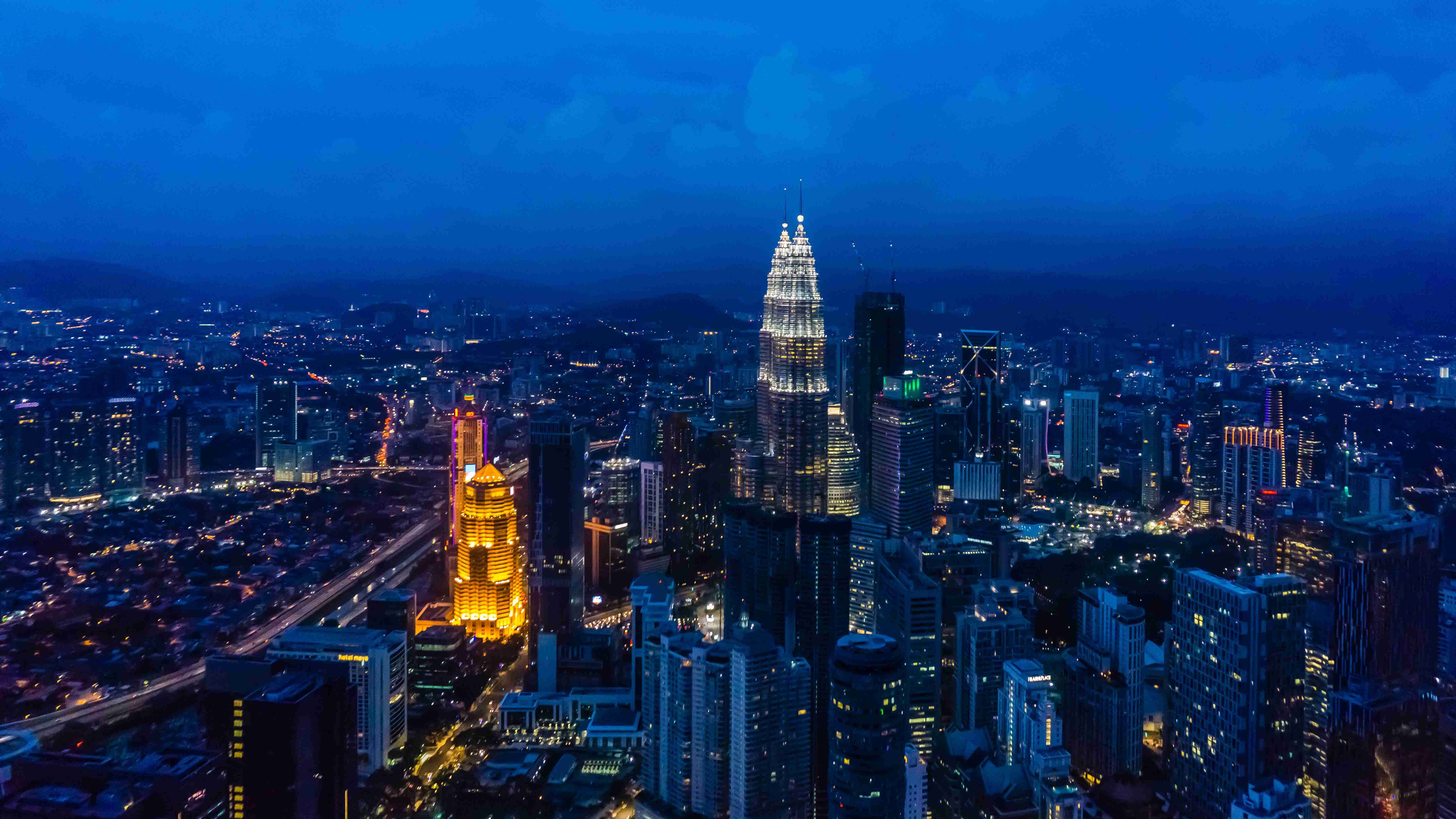 Kvala Lumpūro miesto vaizdas naktį su apšviestais dangoraižiais