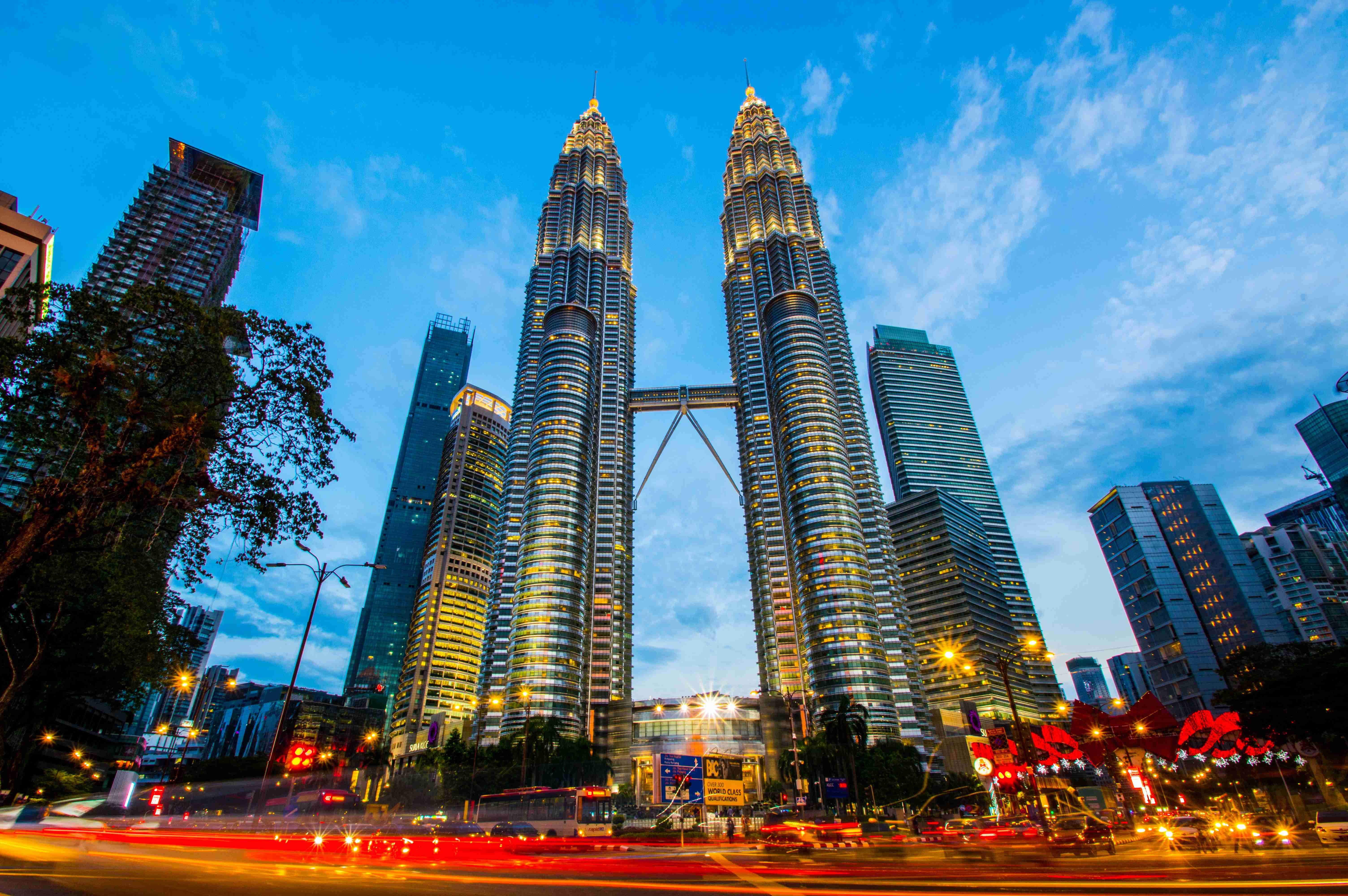 Turnurile Petronas Kuala Lumpur la amurg cu trafic urban