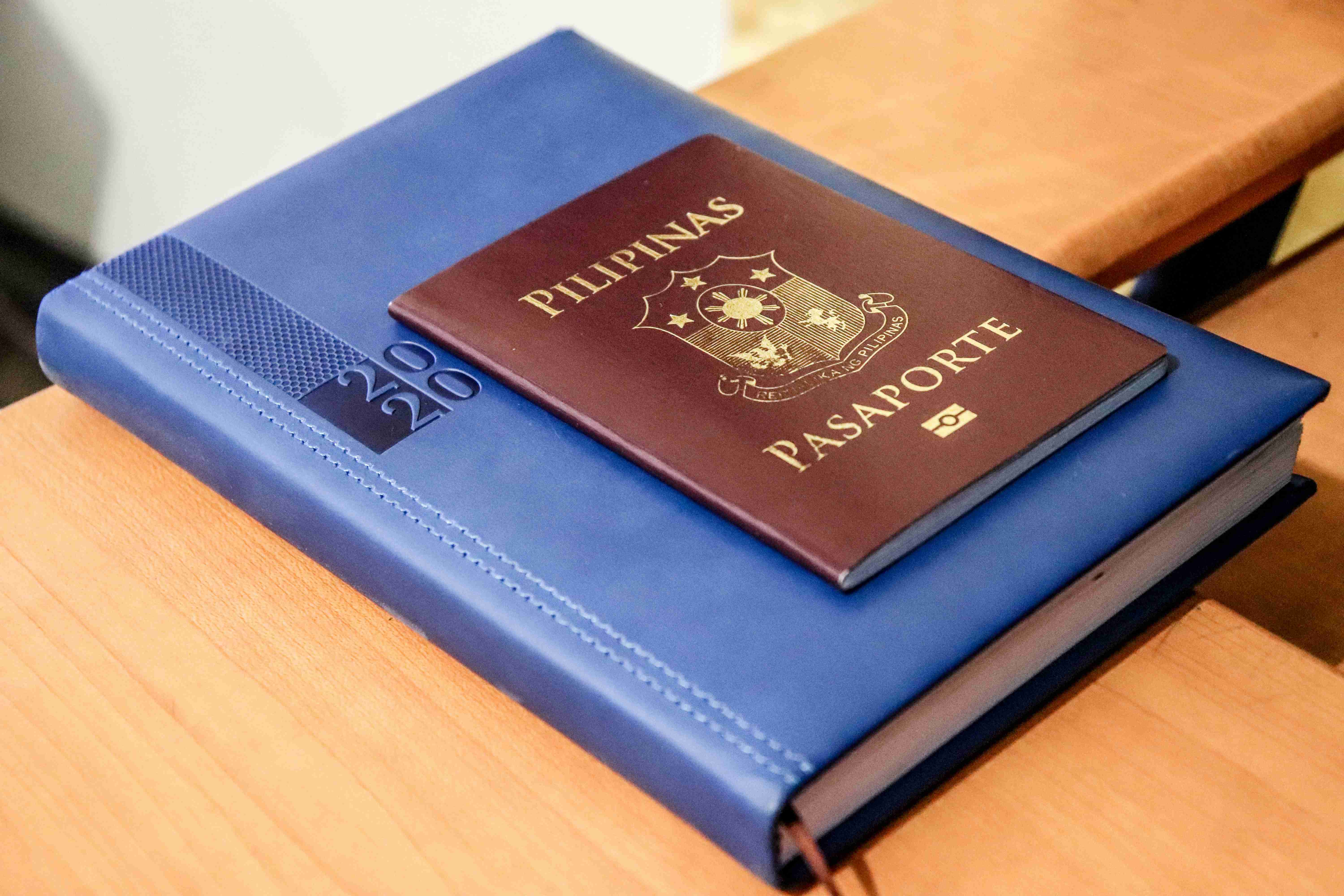 Passaporte filipino e diário na mesa