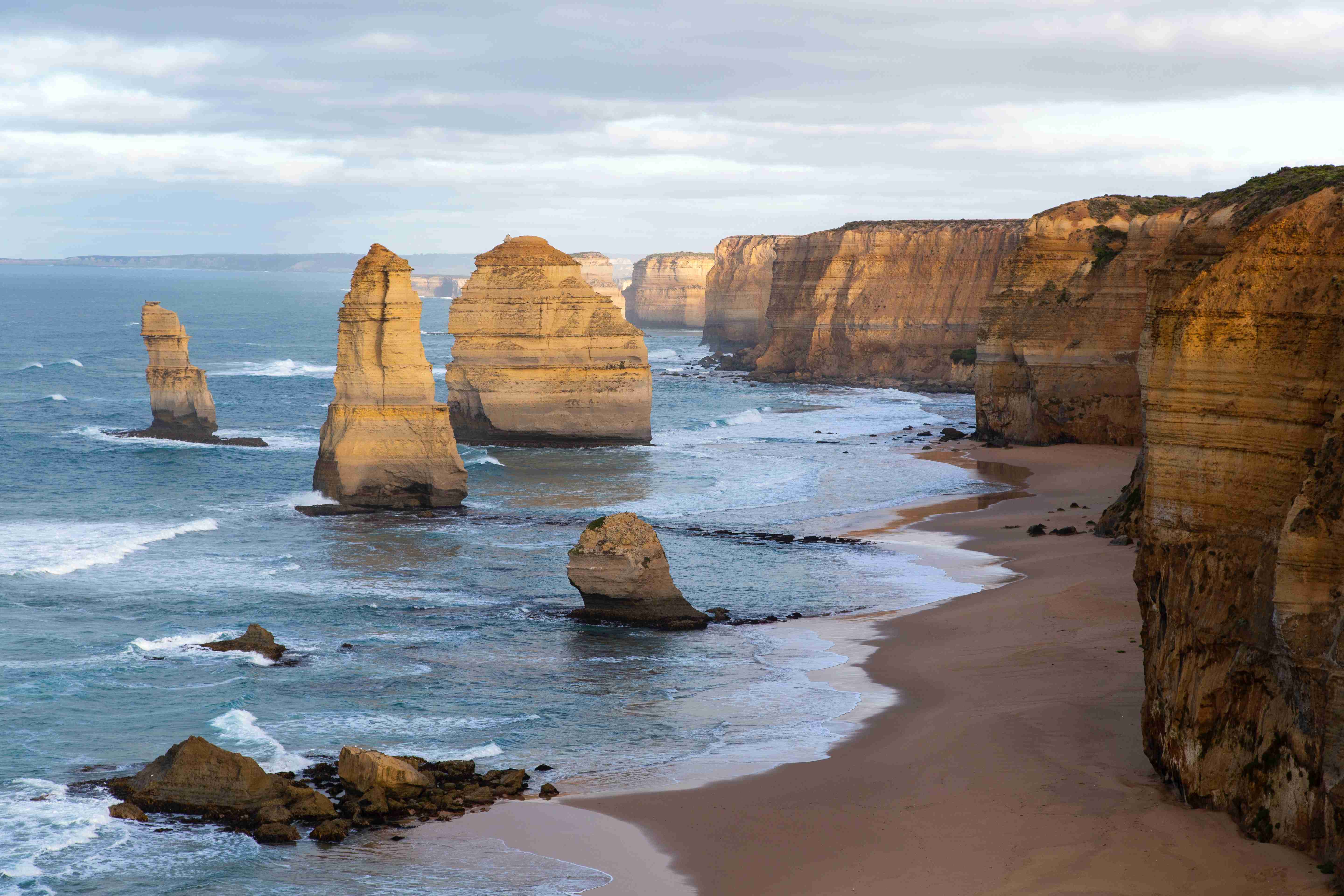 rugged cliffs rock formation on sea shore during daytime