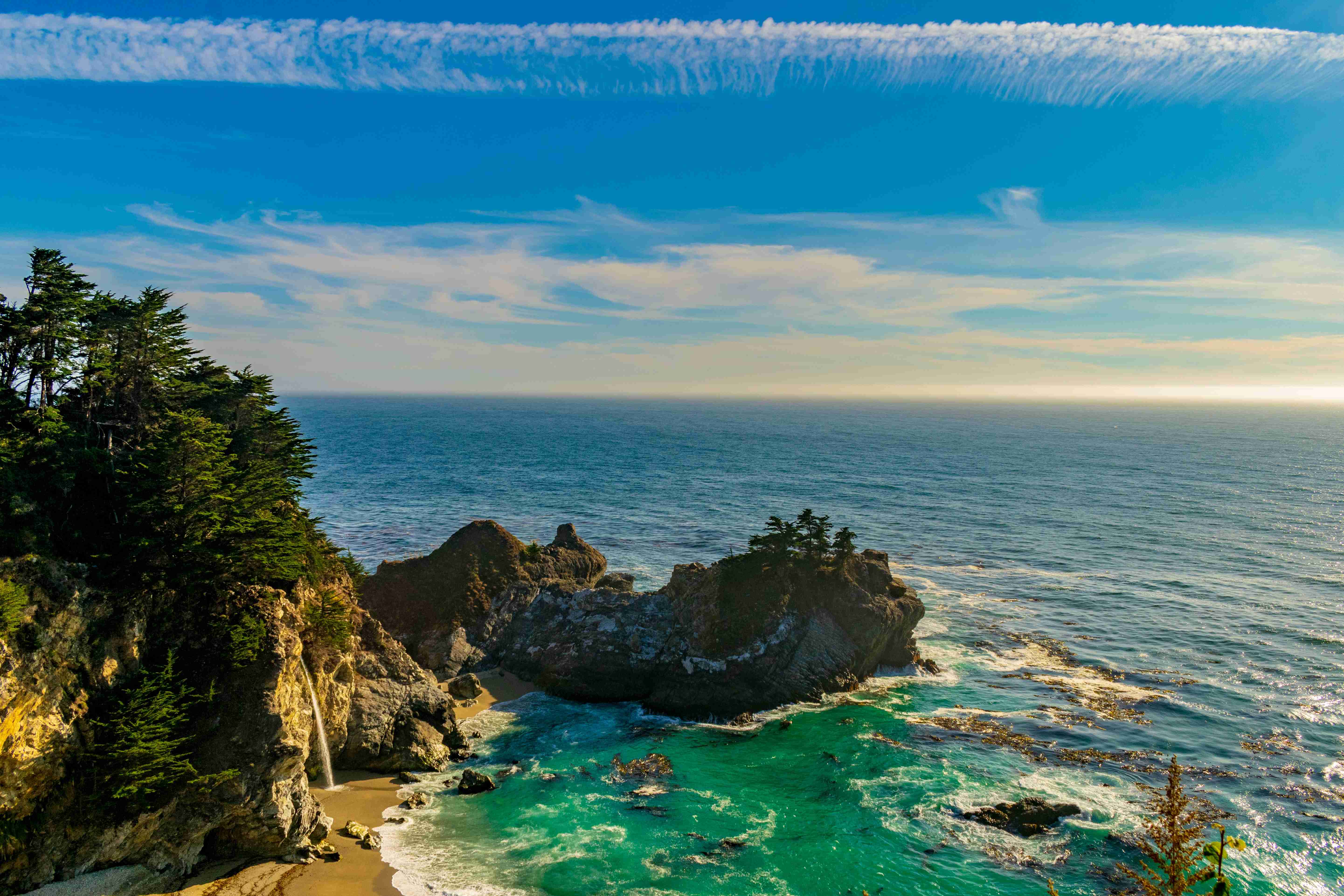 آبشار منزوی روی صخره های ساحلی در غروب آفتاب