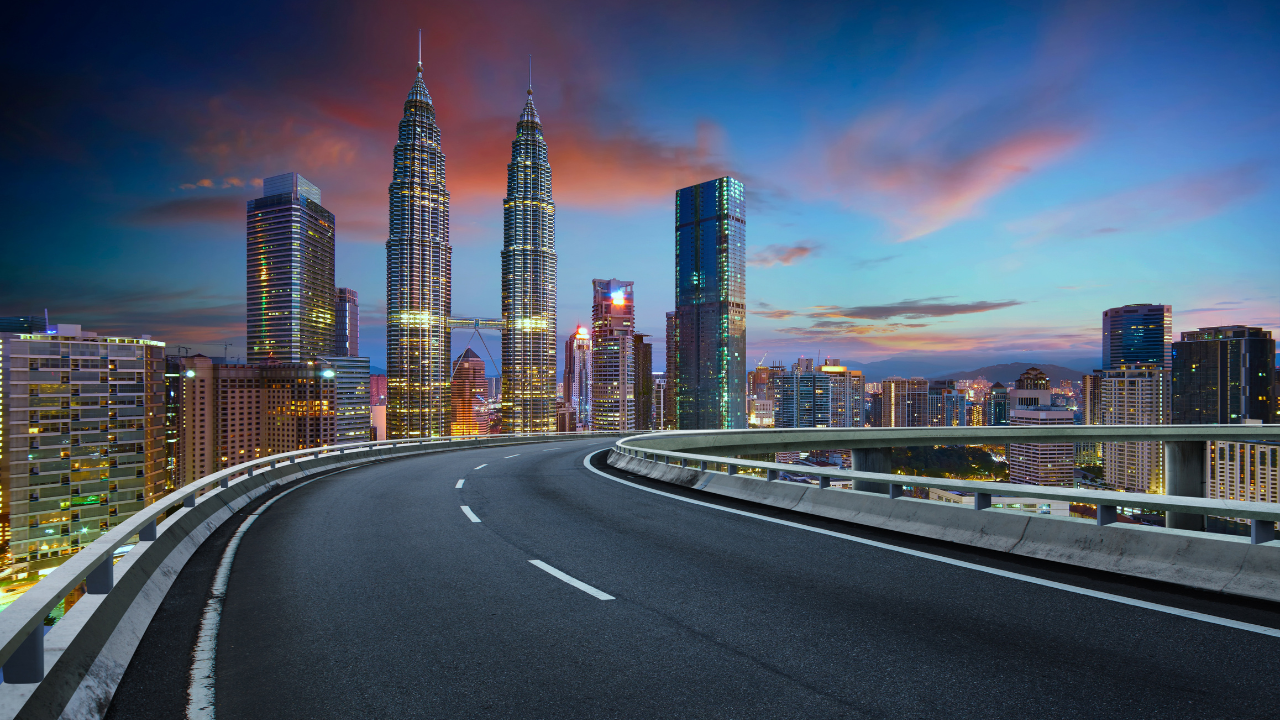 „Магистрала, водеща до хоризонта на Куала Лумпур по здрач“