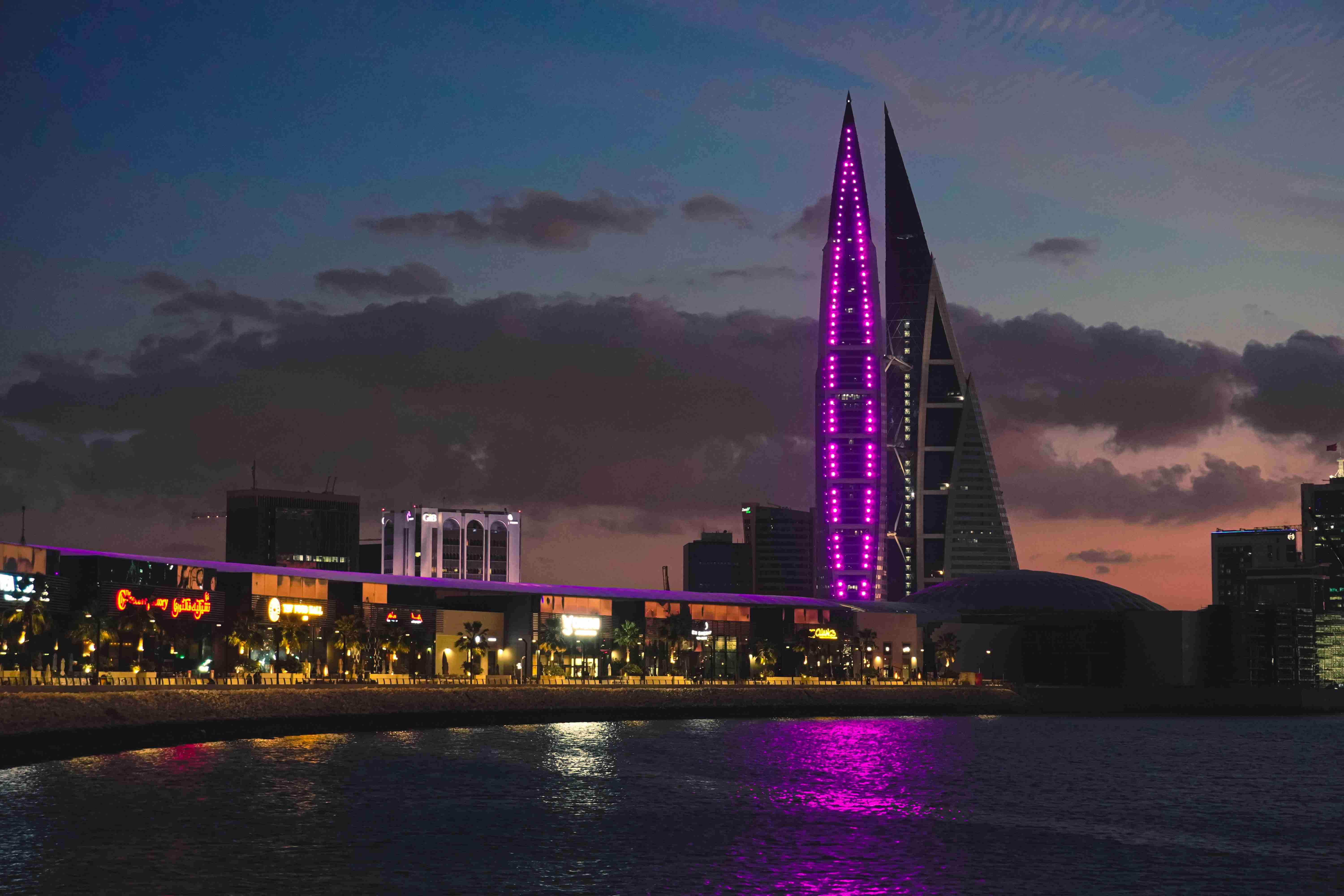 a very tall building with a purple light on its side