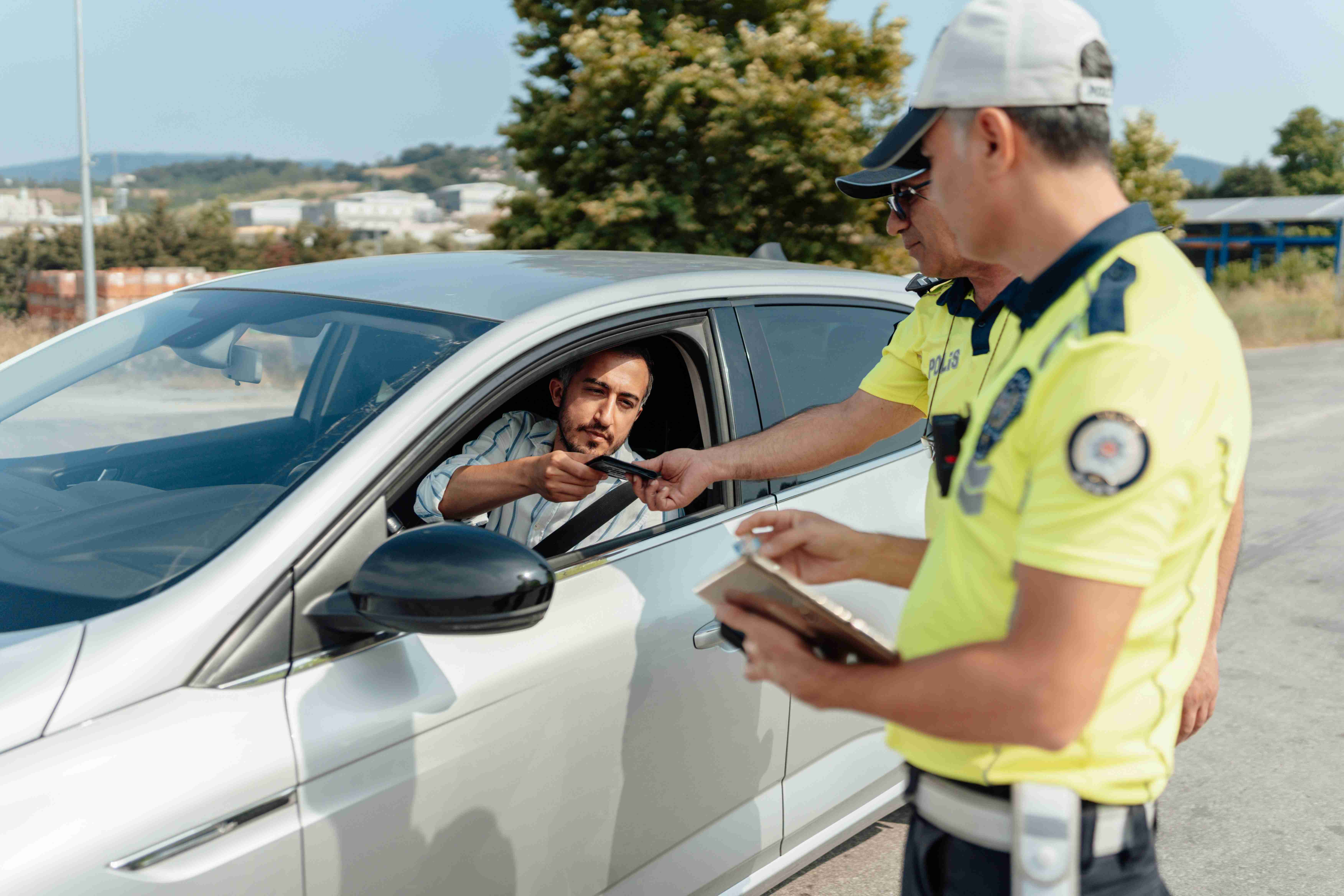 Driver Handing Over License to Traffic Officer