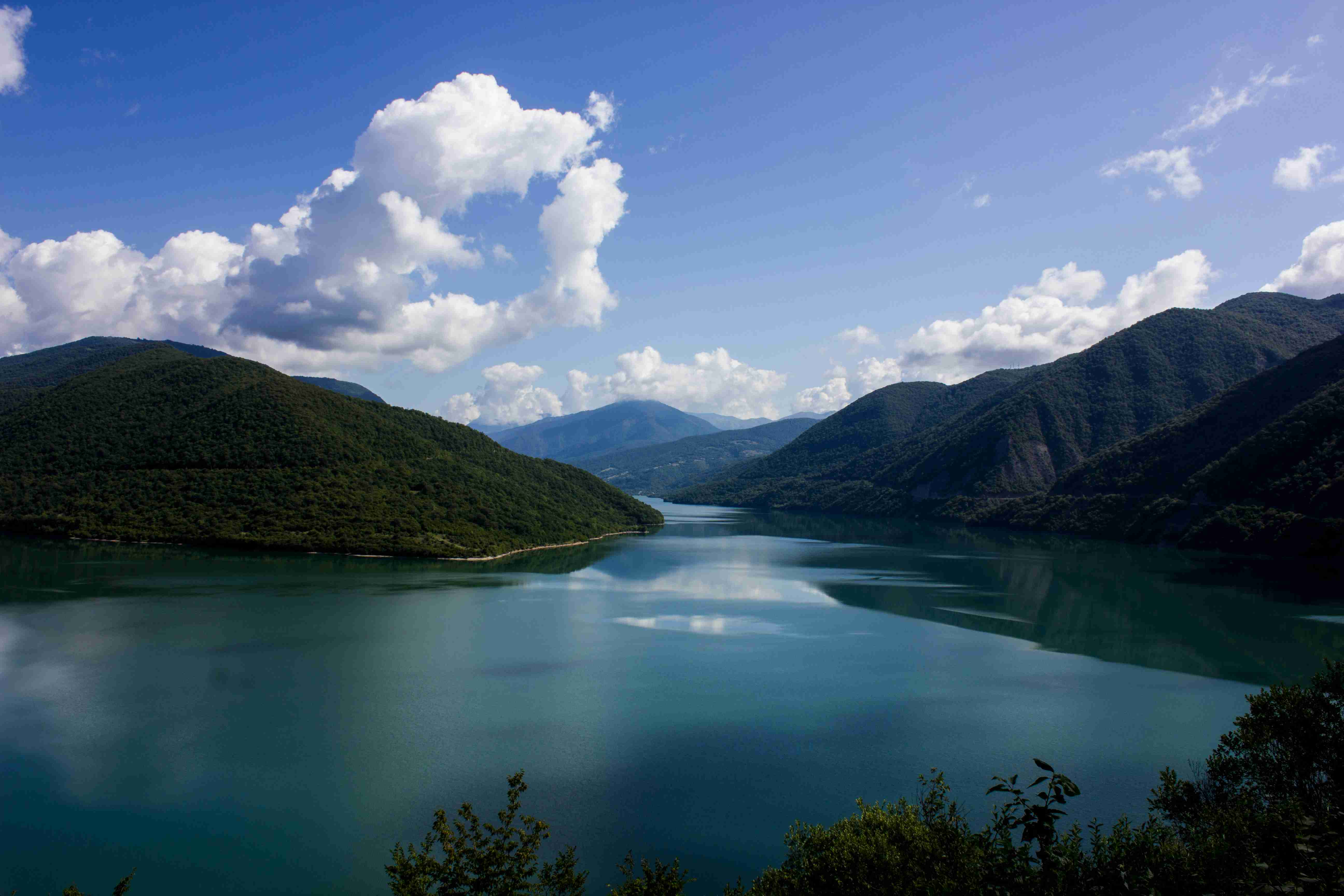 lake-in-the-middle-of-mountains-under-blue-sky