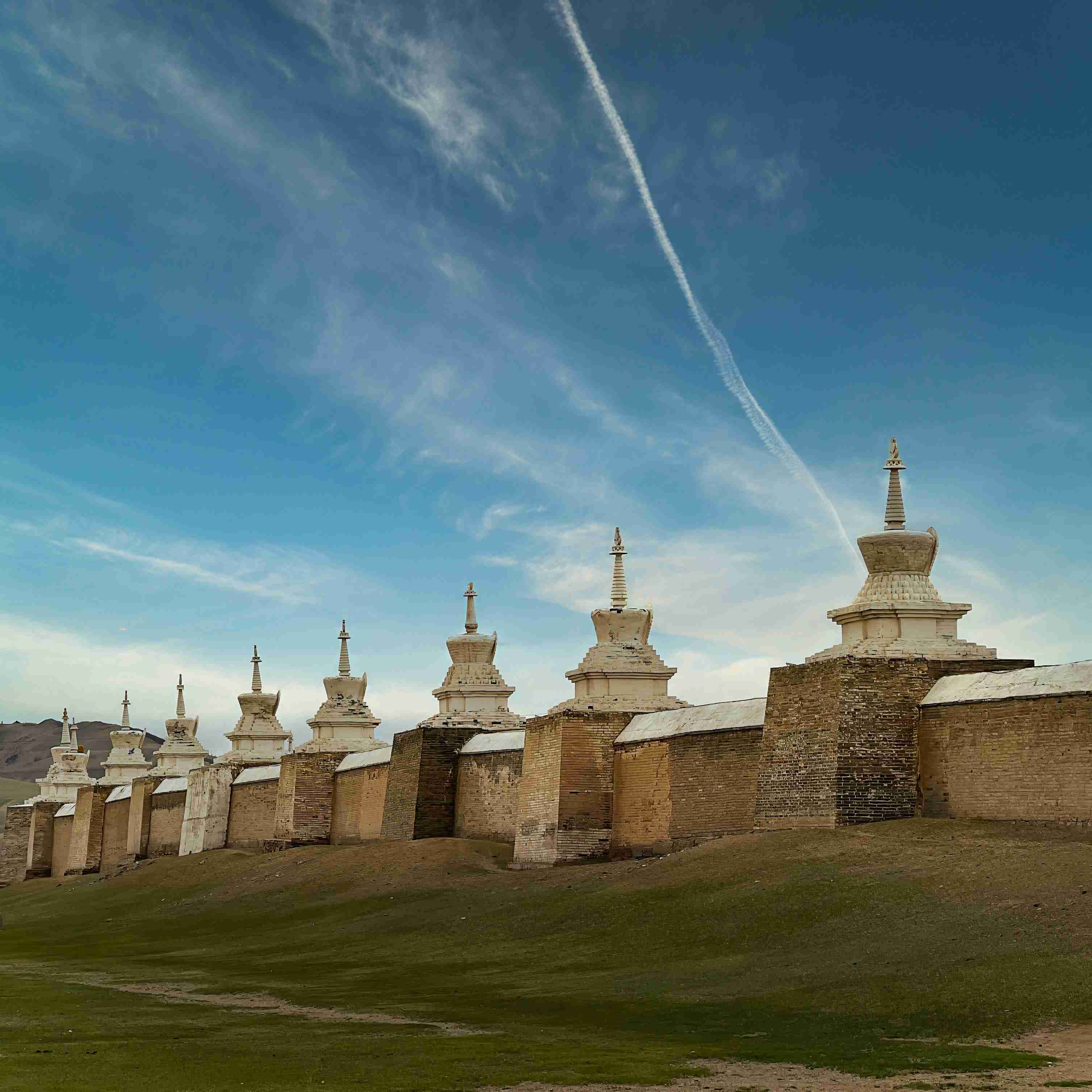 a group of buildings sitting on top of a lush green field