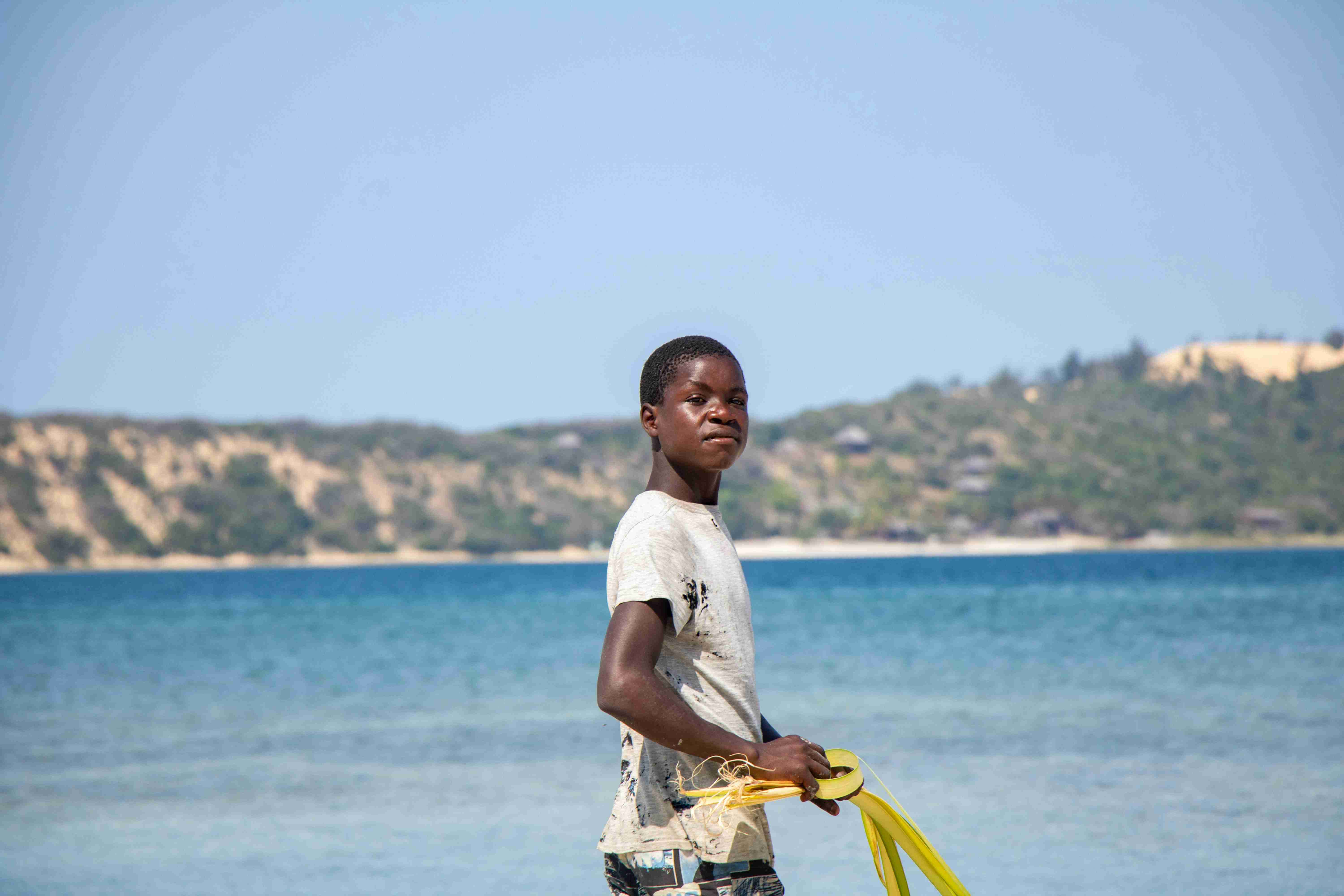 a young boy holding a yellow frisbee