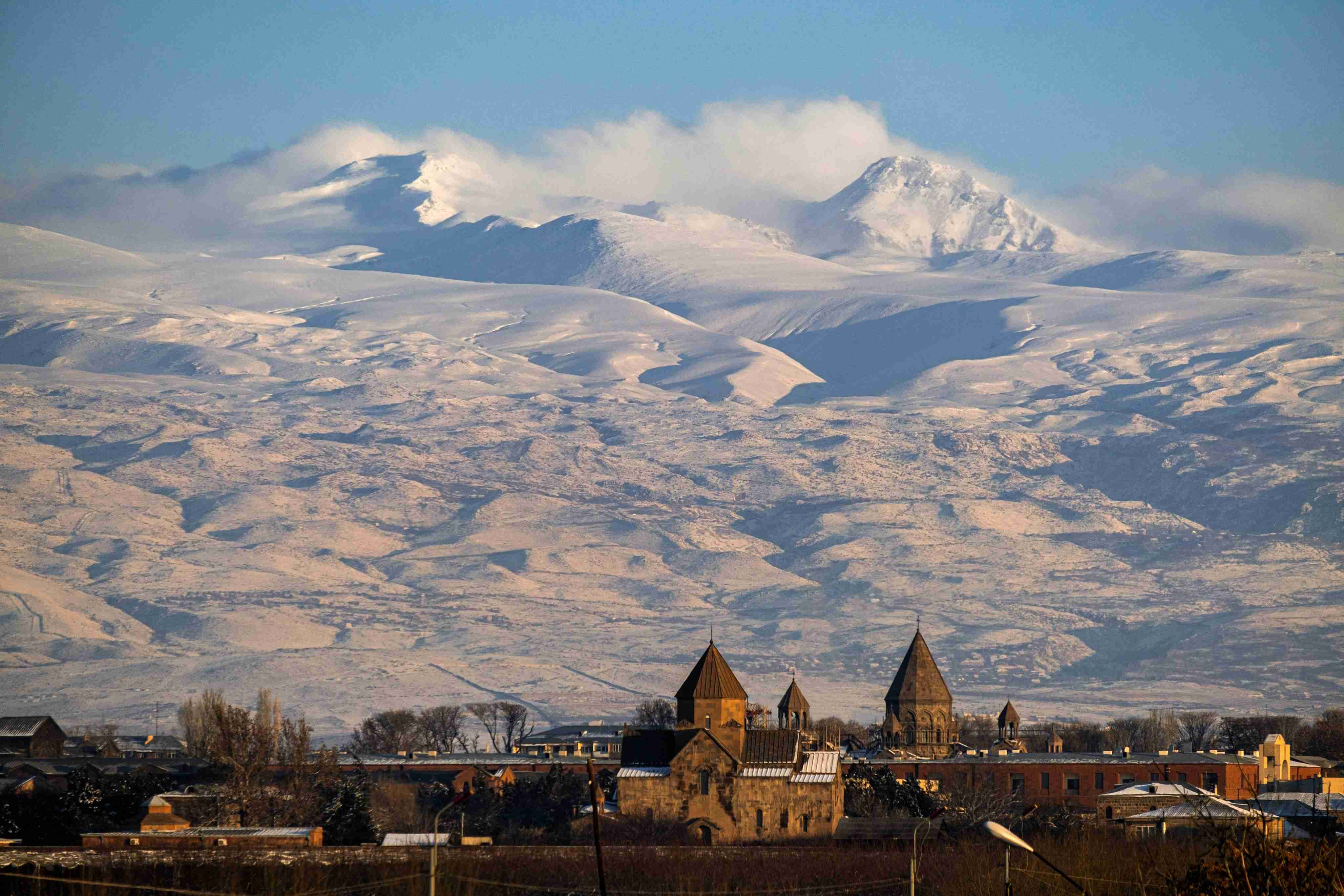 a-view-of-a-mountain-range-with-a-church-in-the-foreground