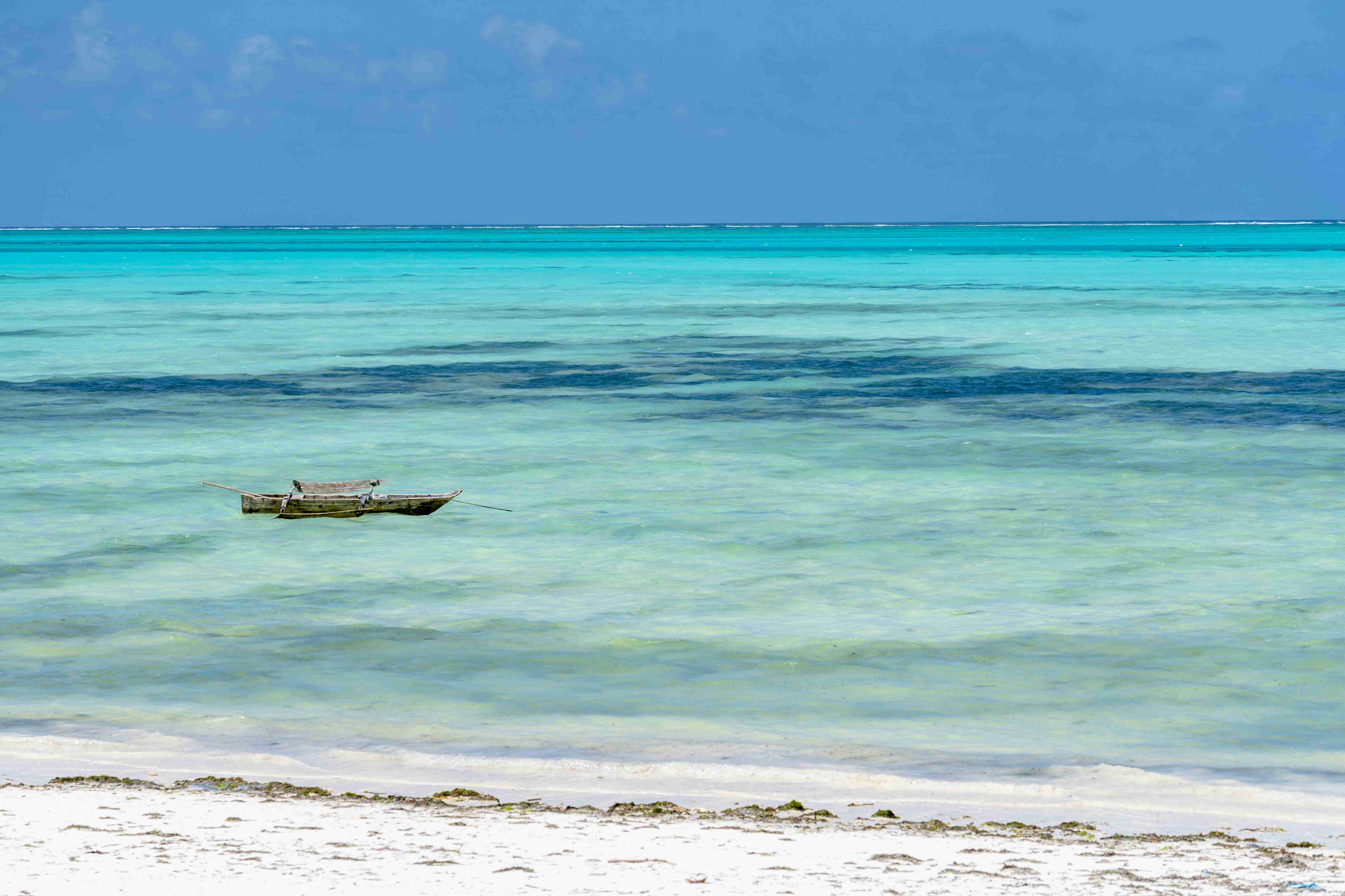 a-small-boat-floating-on-top-of-a-body-of-water