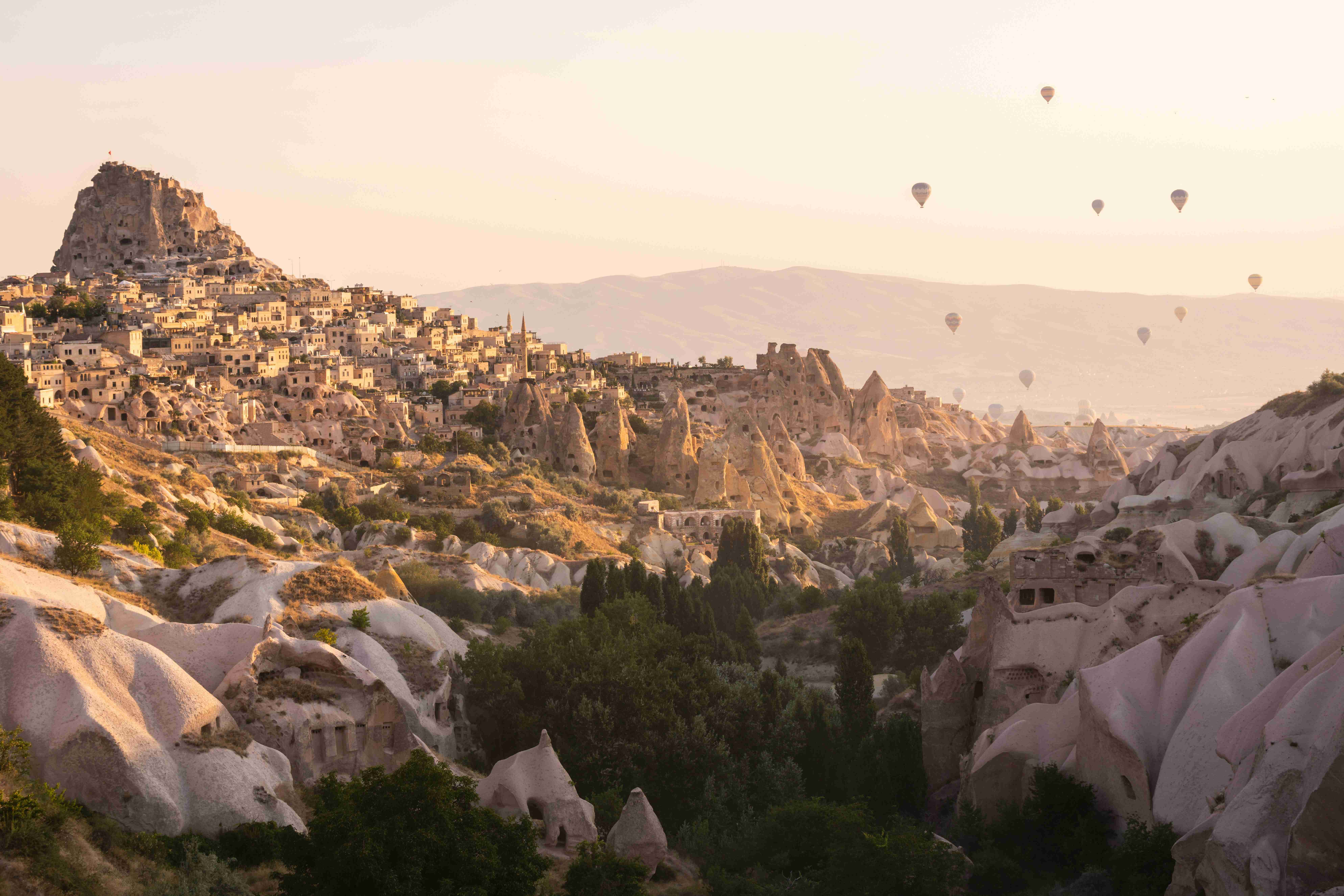 a-group-of-hot-air-balloons-flying-over-a-rocky-landscape
