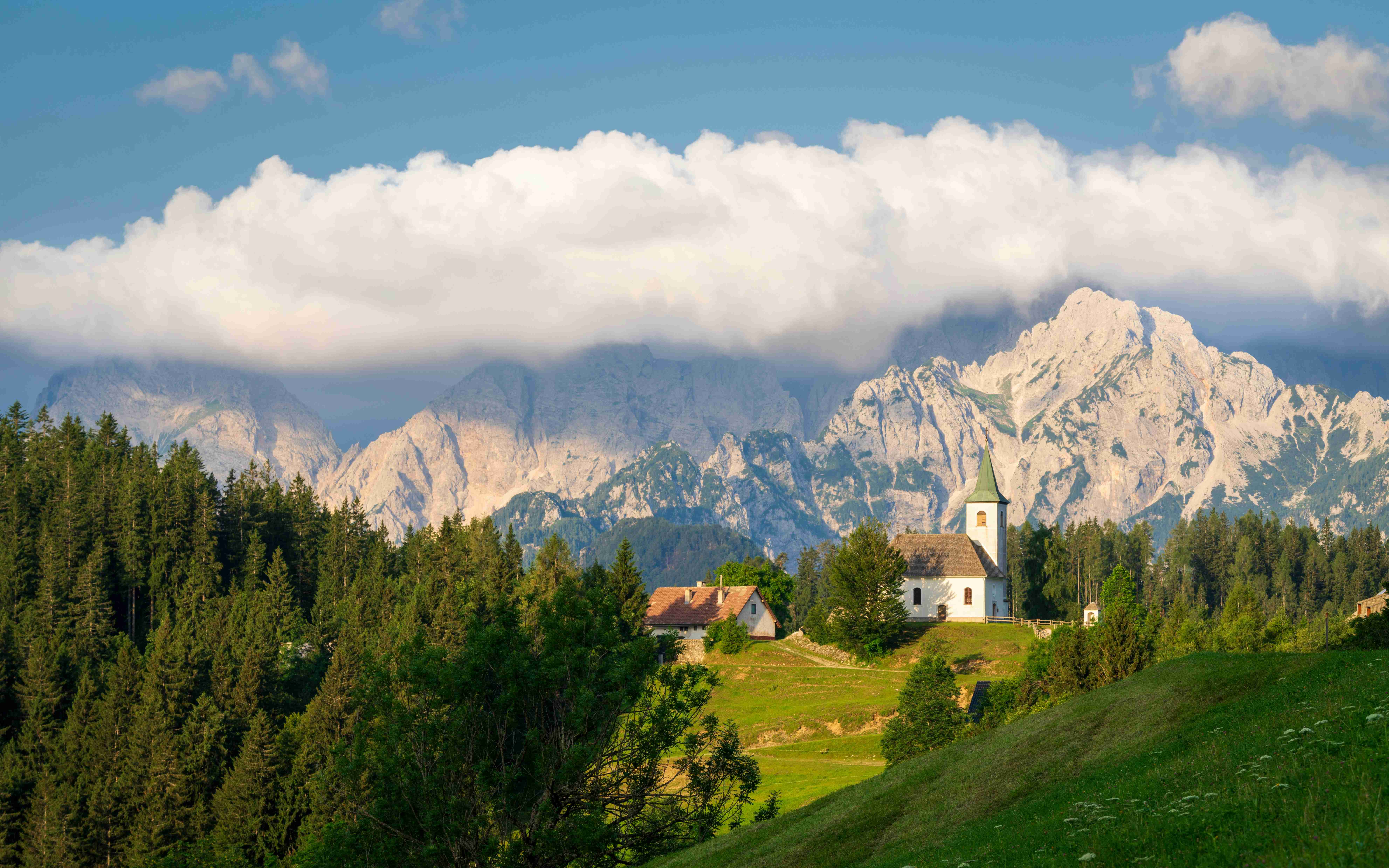 a church on a hill with mountains