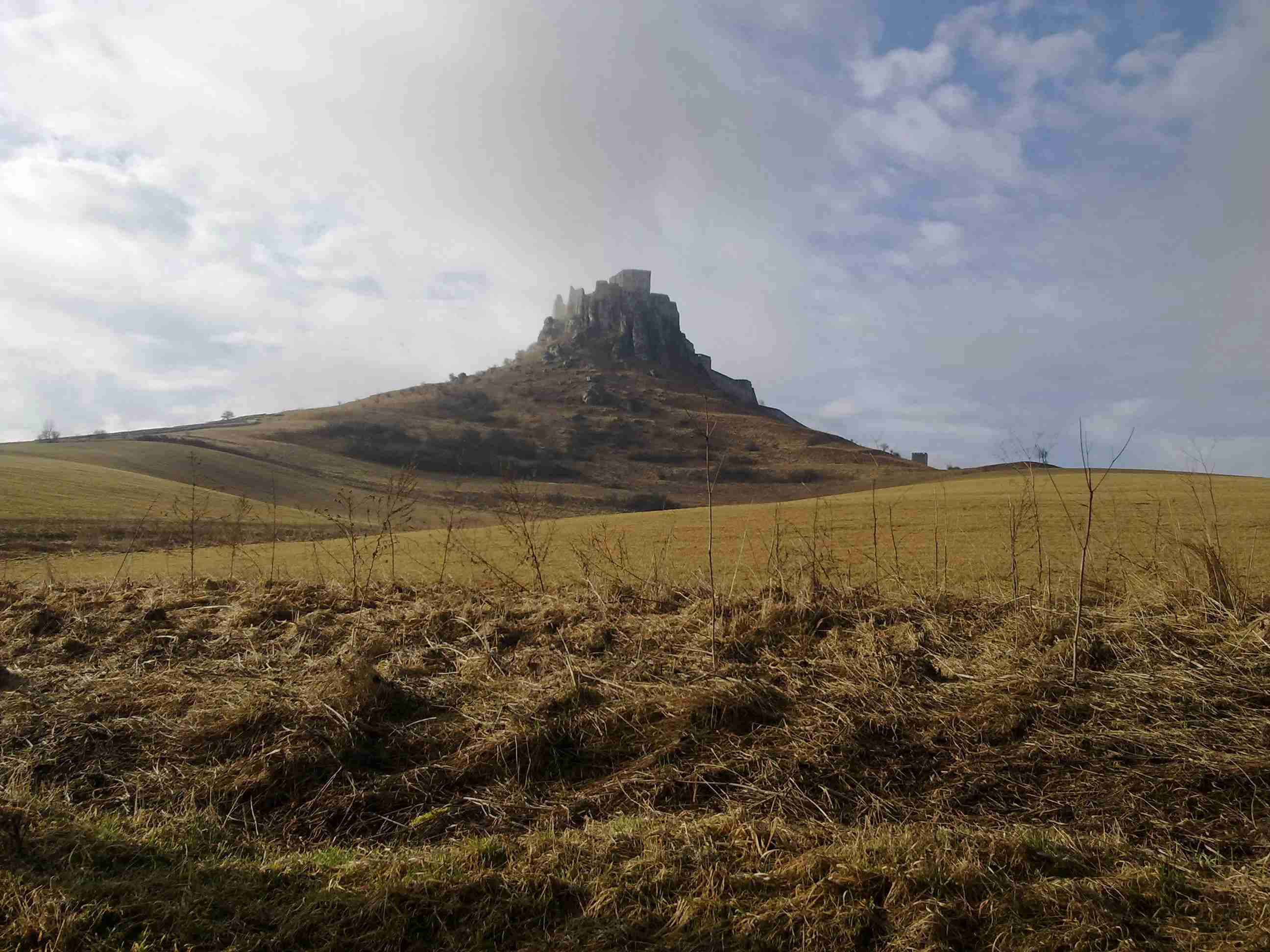 brown-field-near-brown-mountain-under-white-clouds