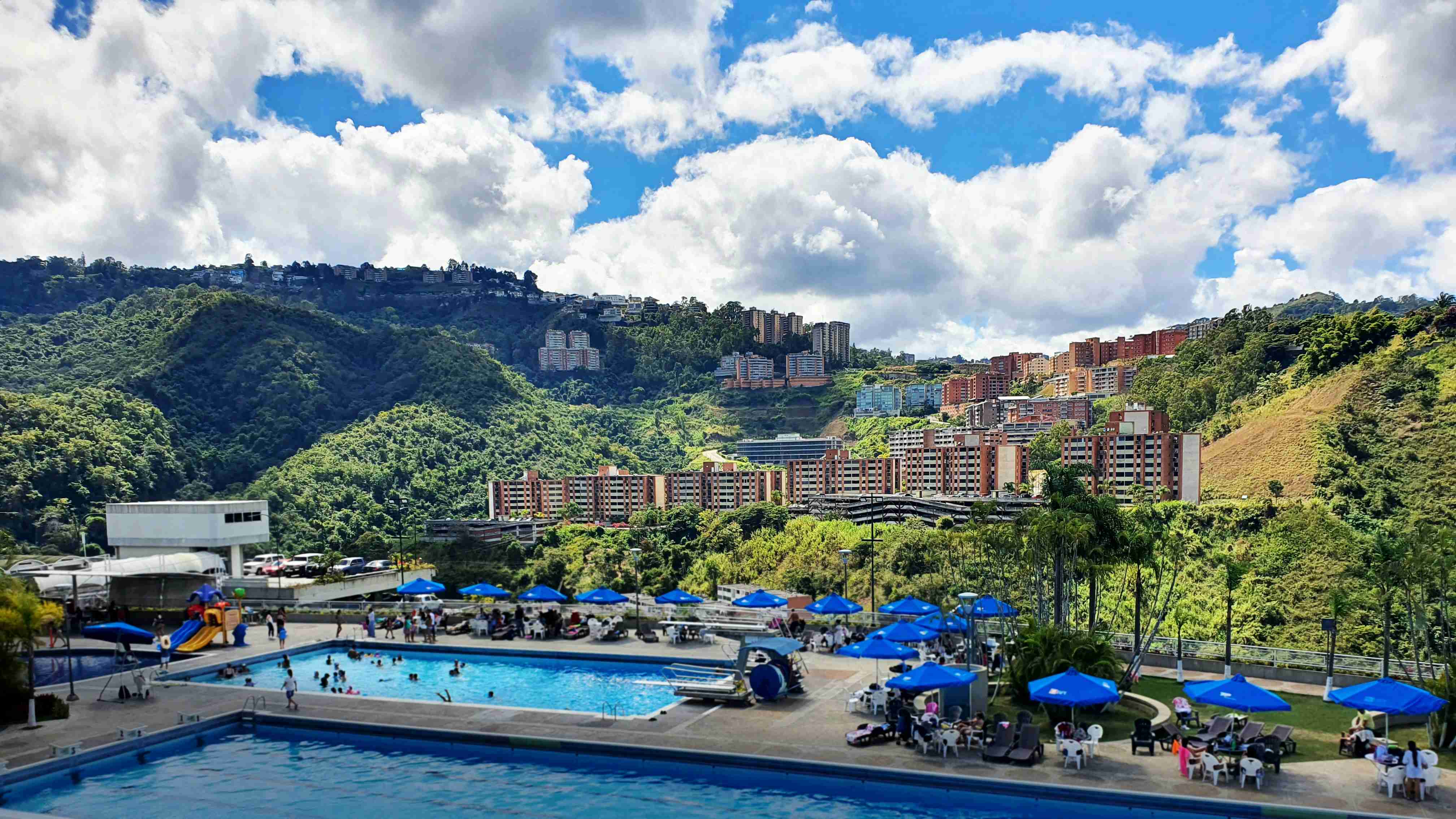 didelis baseinas, apsuptas vešlios žalios kalvos šlaito