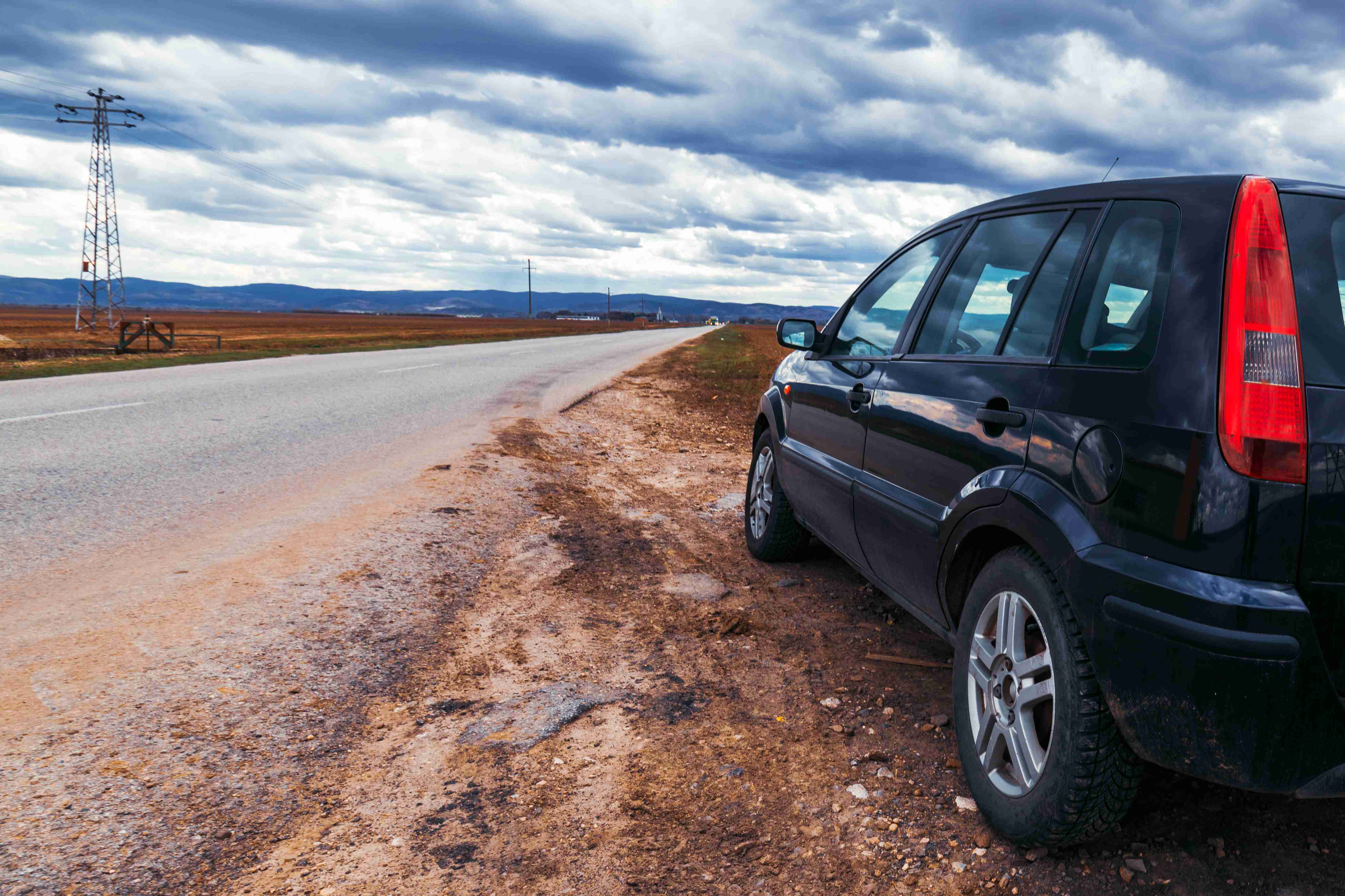 Ødelagt bil stoppet ved vejen på stormfuld dag