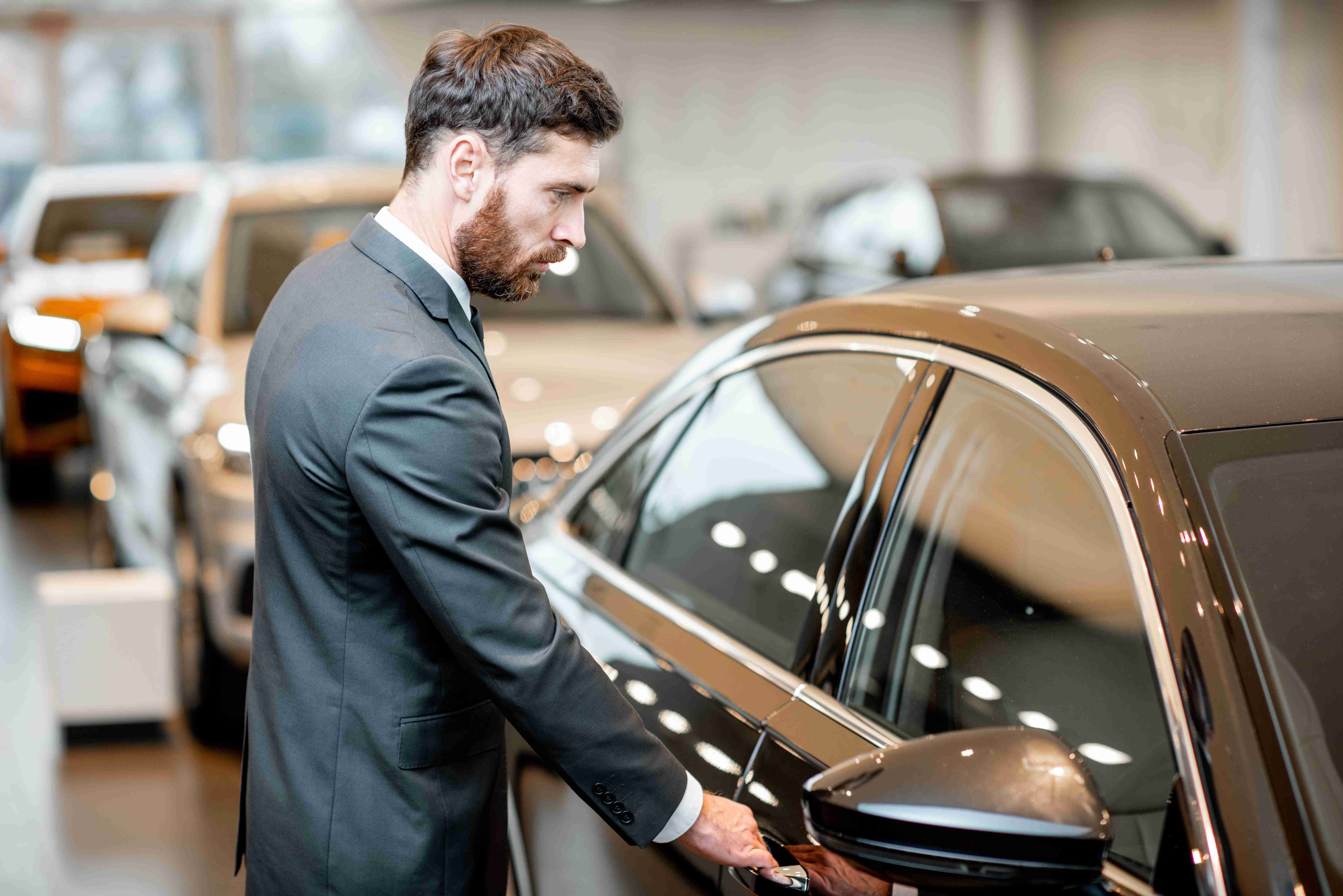 businessman-choosing-car-in-the-showroom