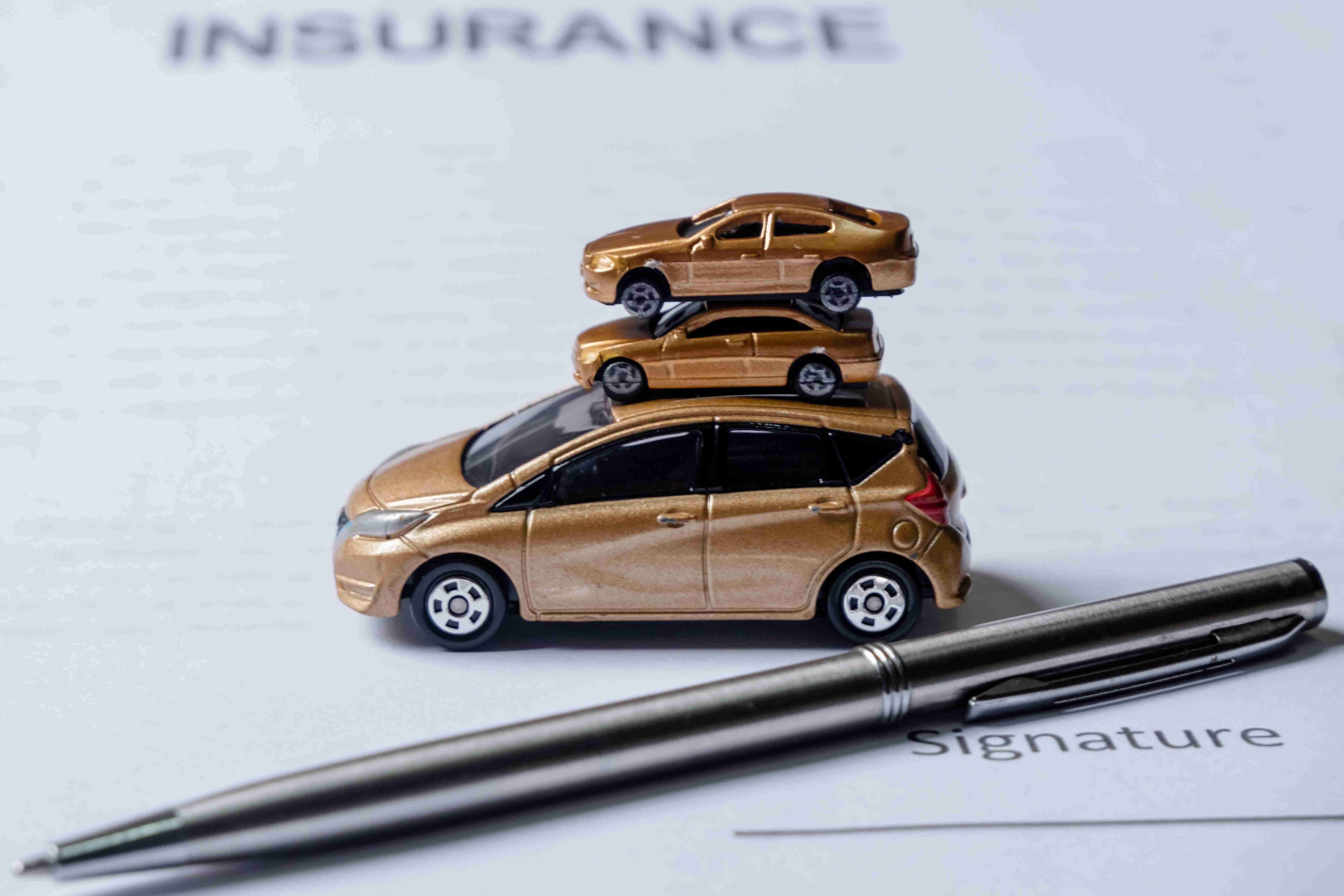 Car and pen on insurance documents