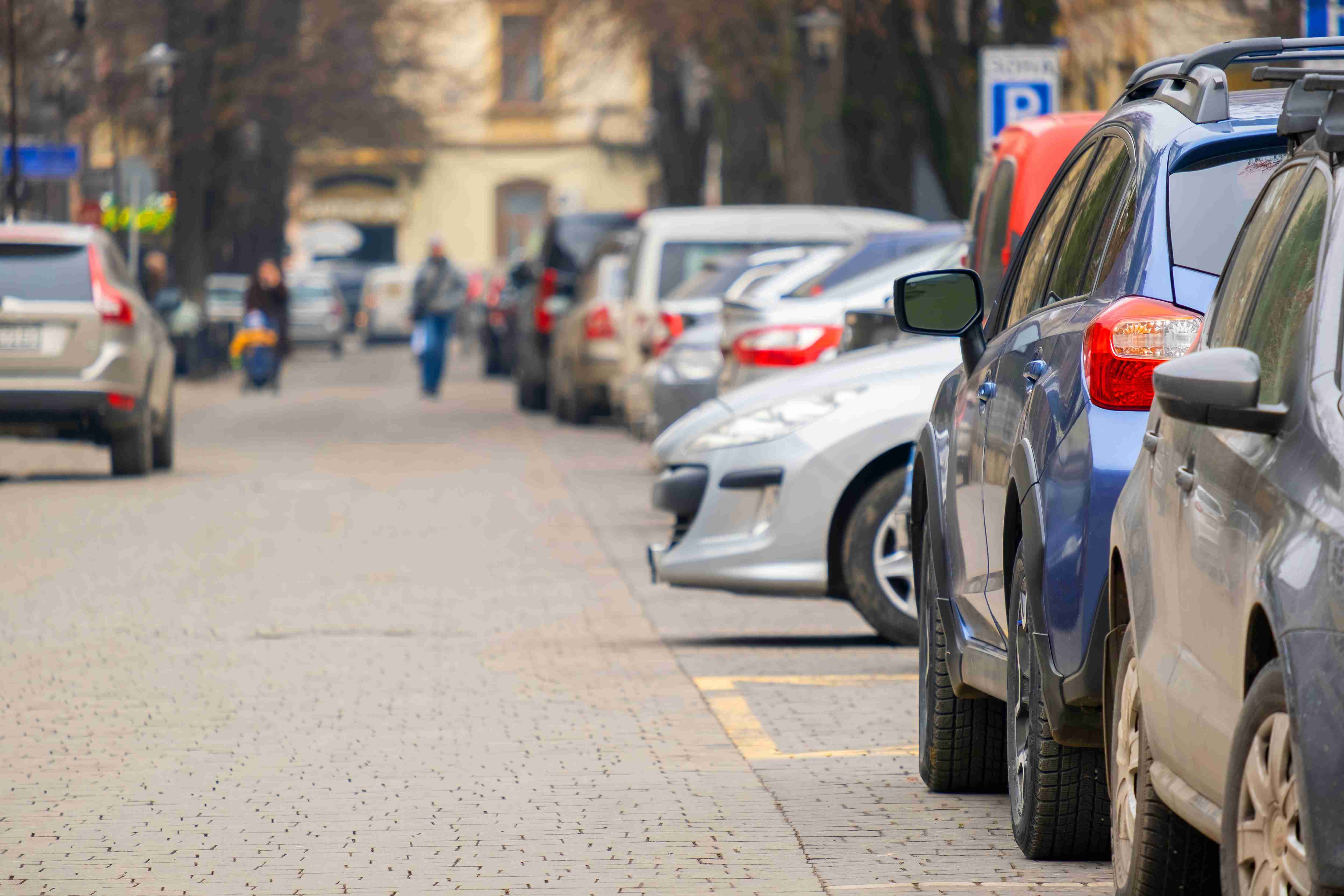 Cars parked in a row on a city street side