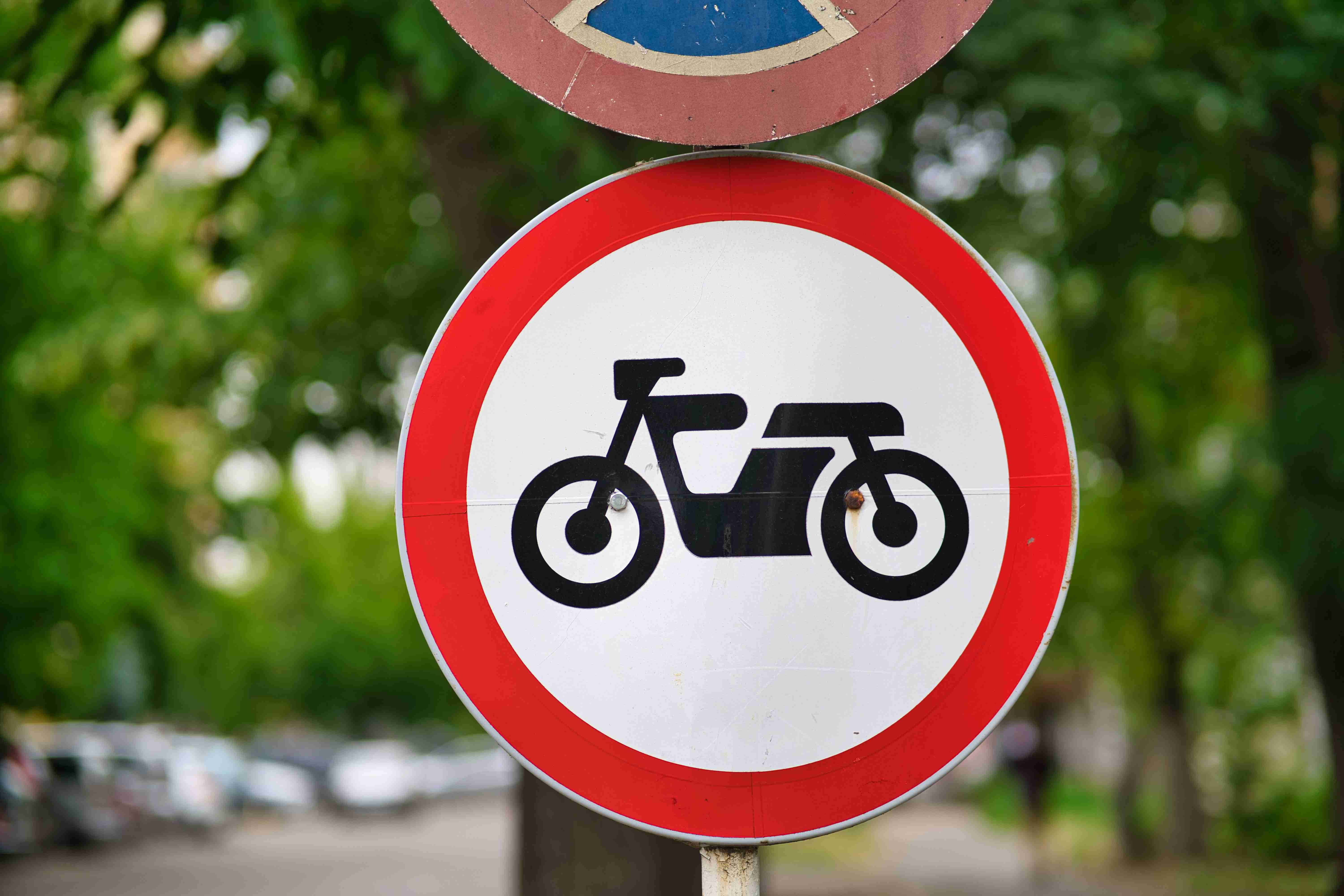 Closeup of a road sign indicating that motorcycles are forbidden to proceed