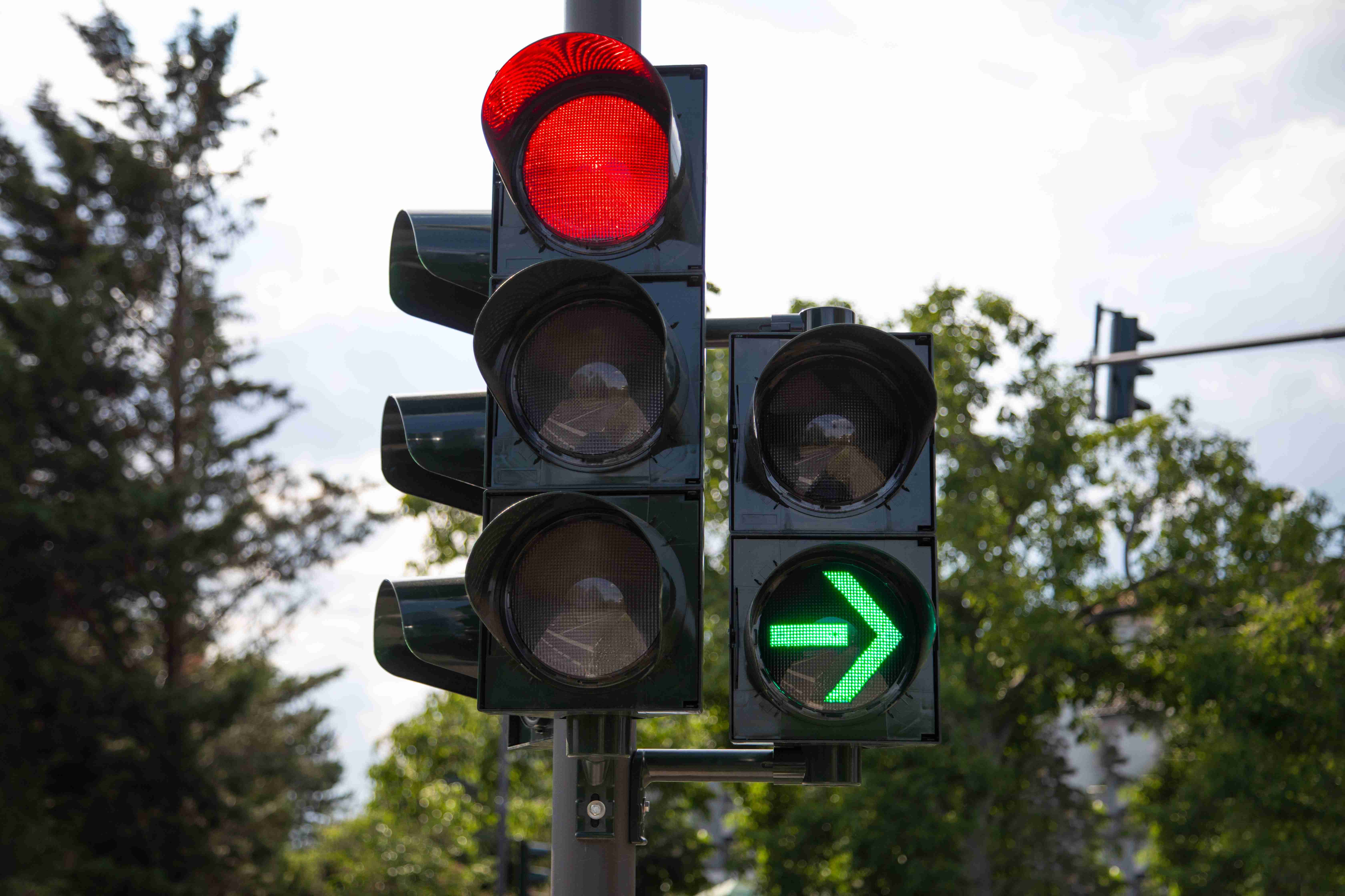 closeup-of-red-traffic-light-with-green-arrow-light