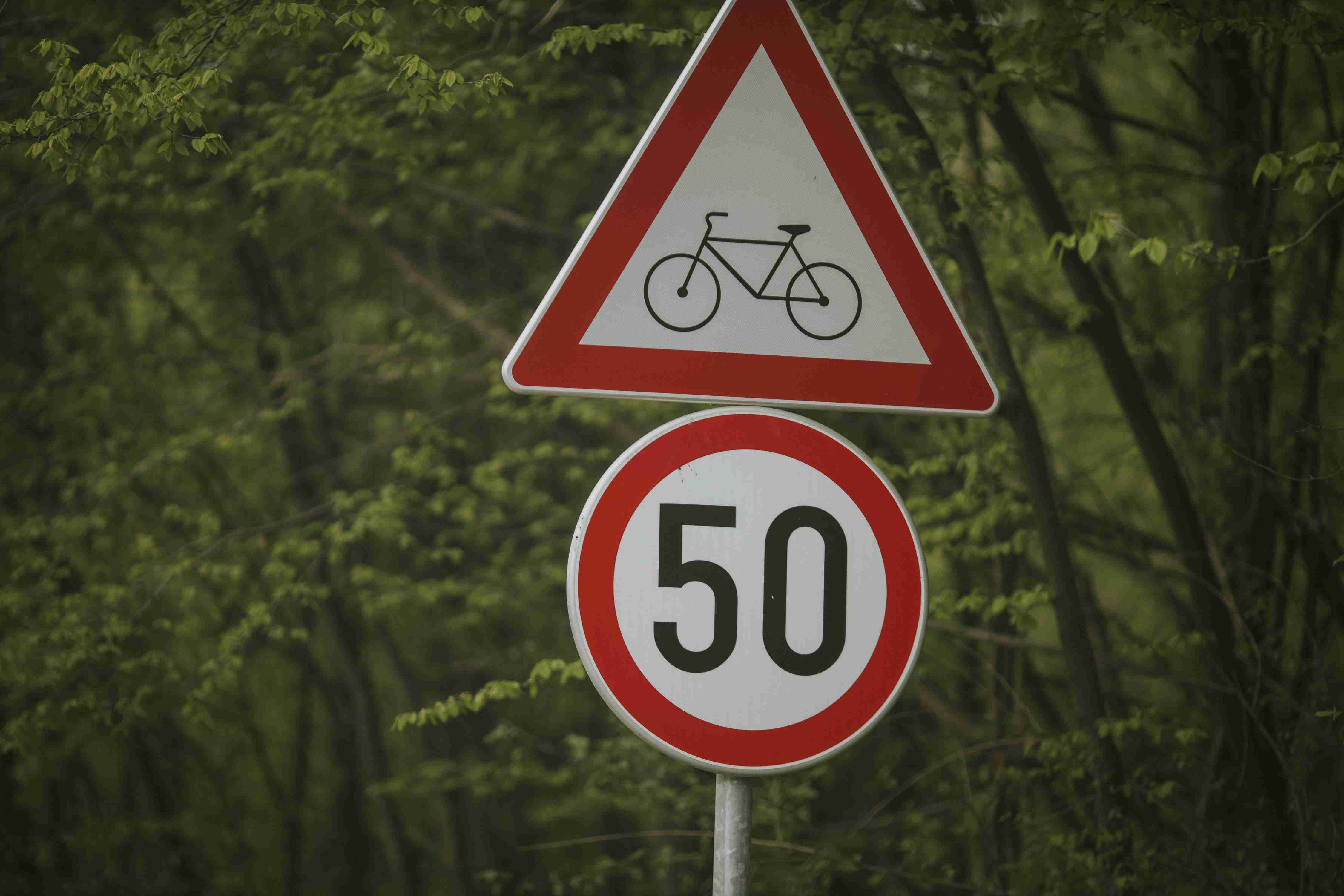 closeup-shot-of-a-speed-limit-and-bike-trail-sign