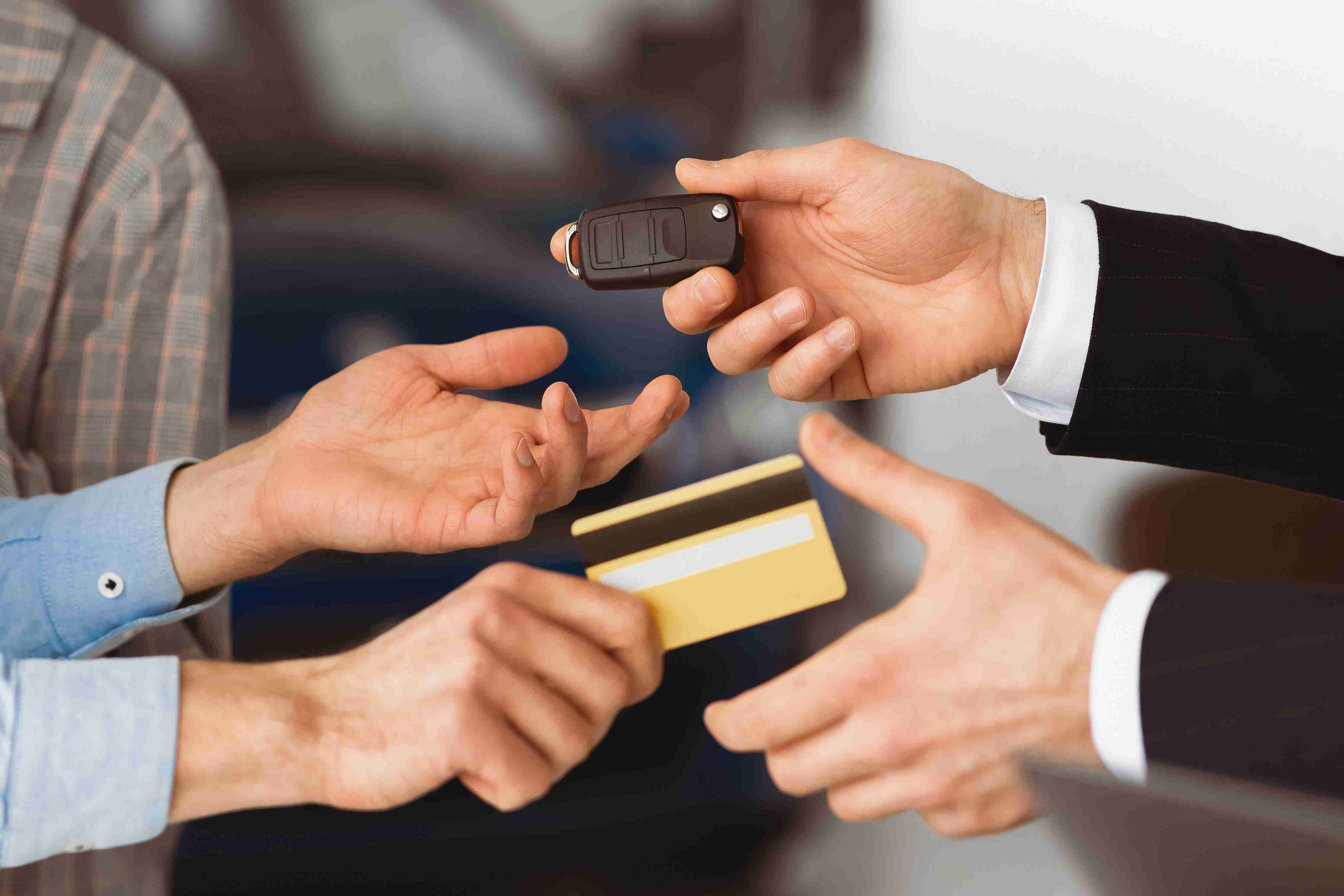 Couple Buying Car Giving Seller Credit Card