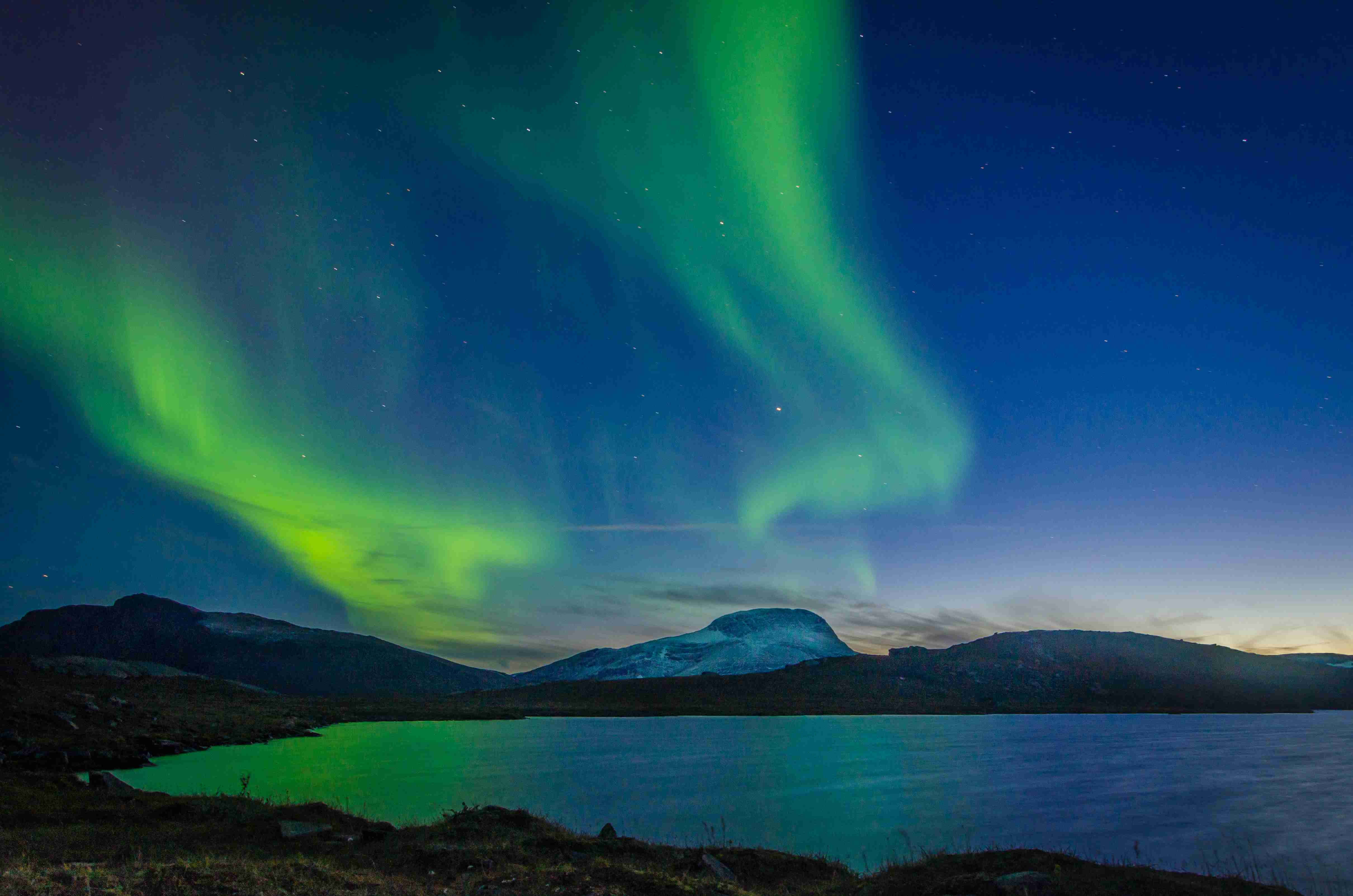 aurora-borealis-over-body-of-water-during-nighttime