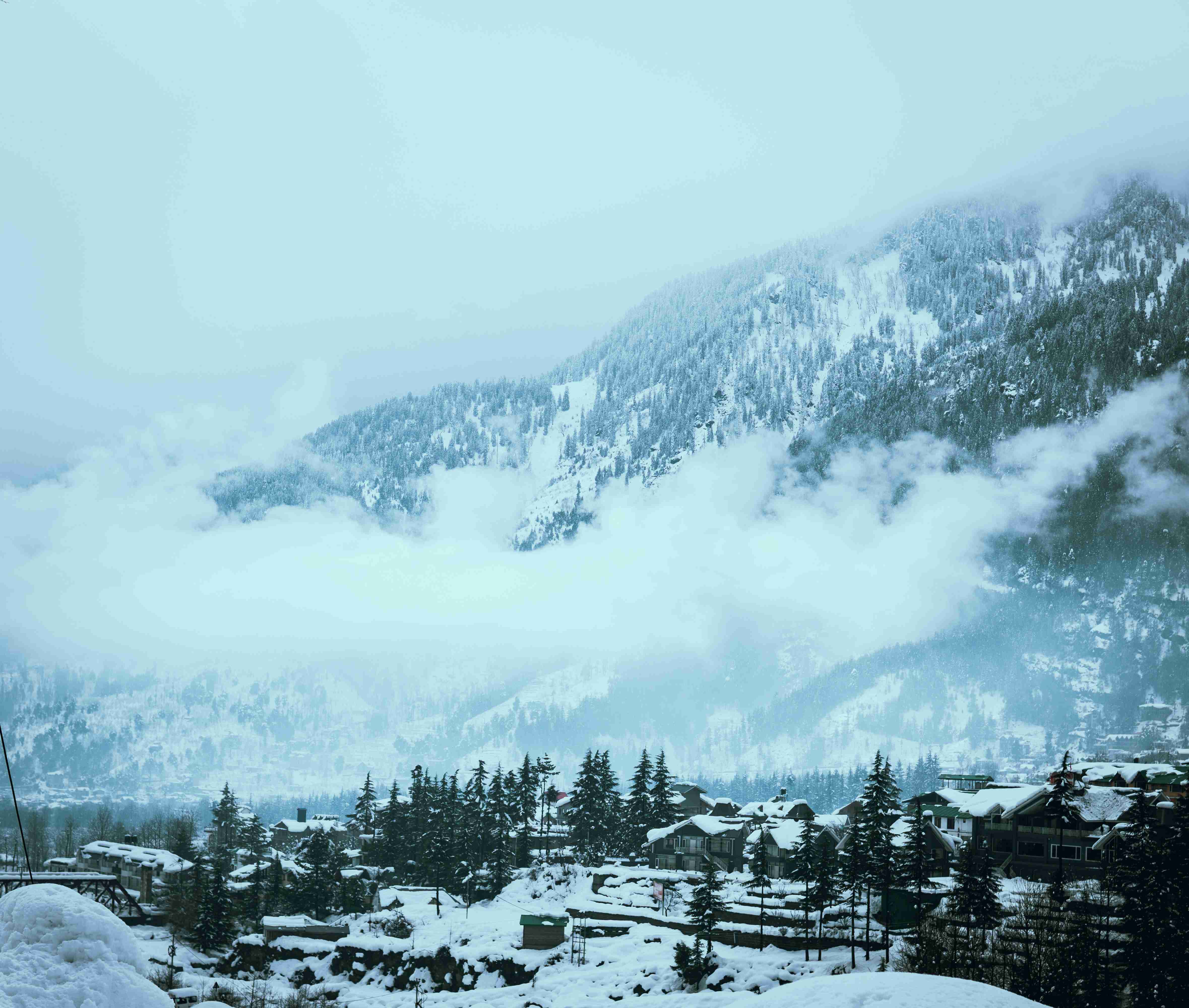 a mountain covered in snow with a sky background