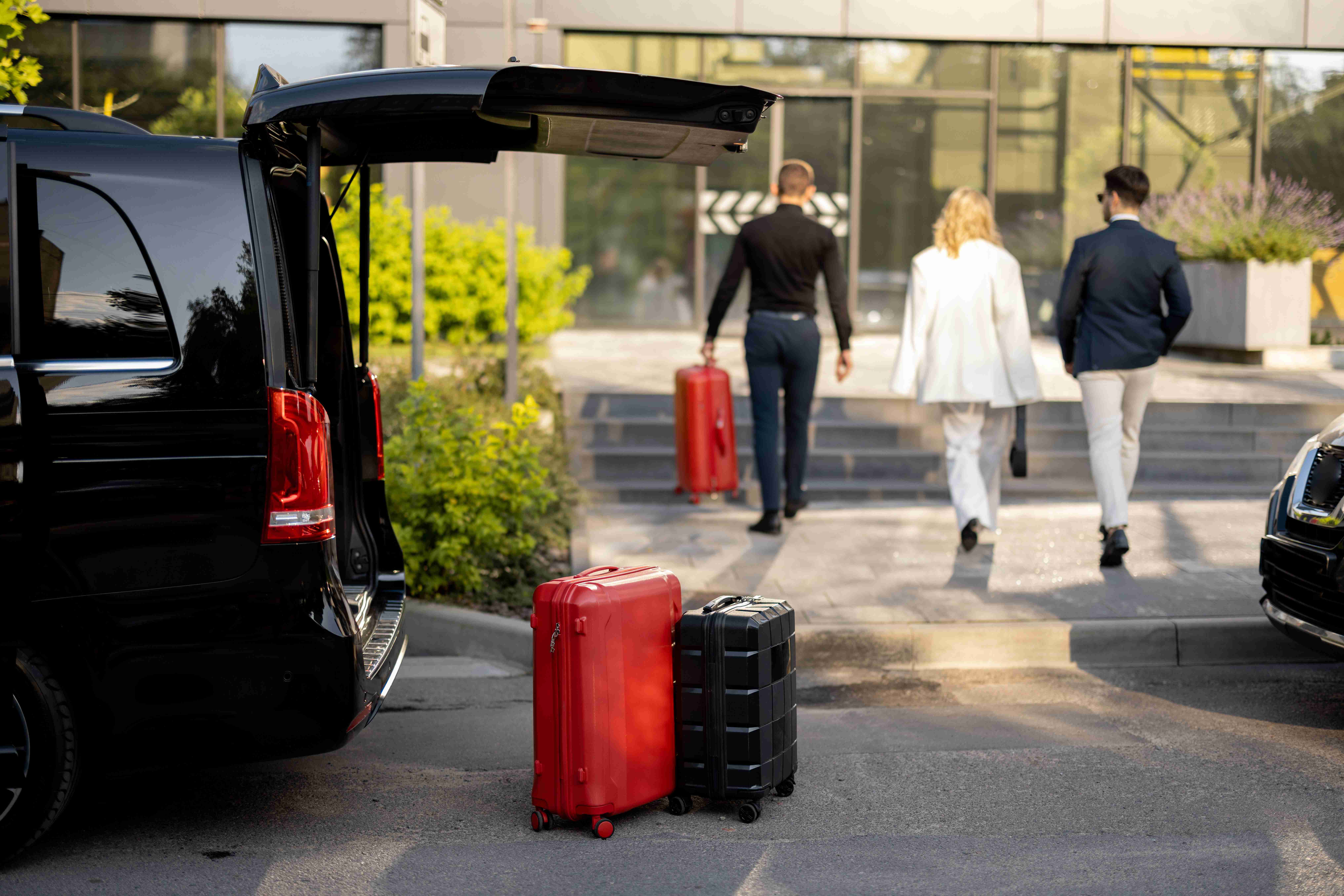 driver-helps-a-business-couple-carry-their-suitcase