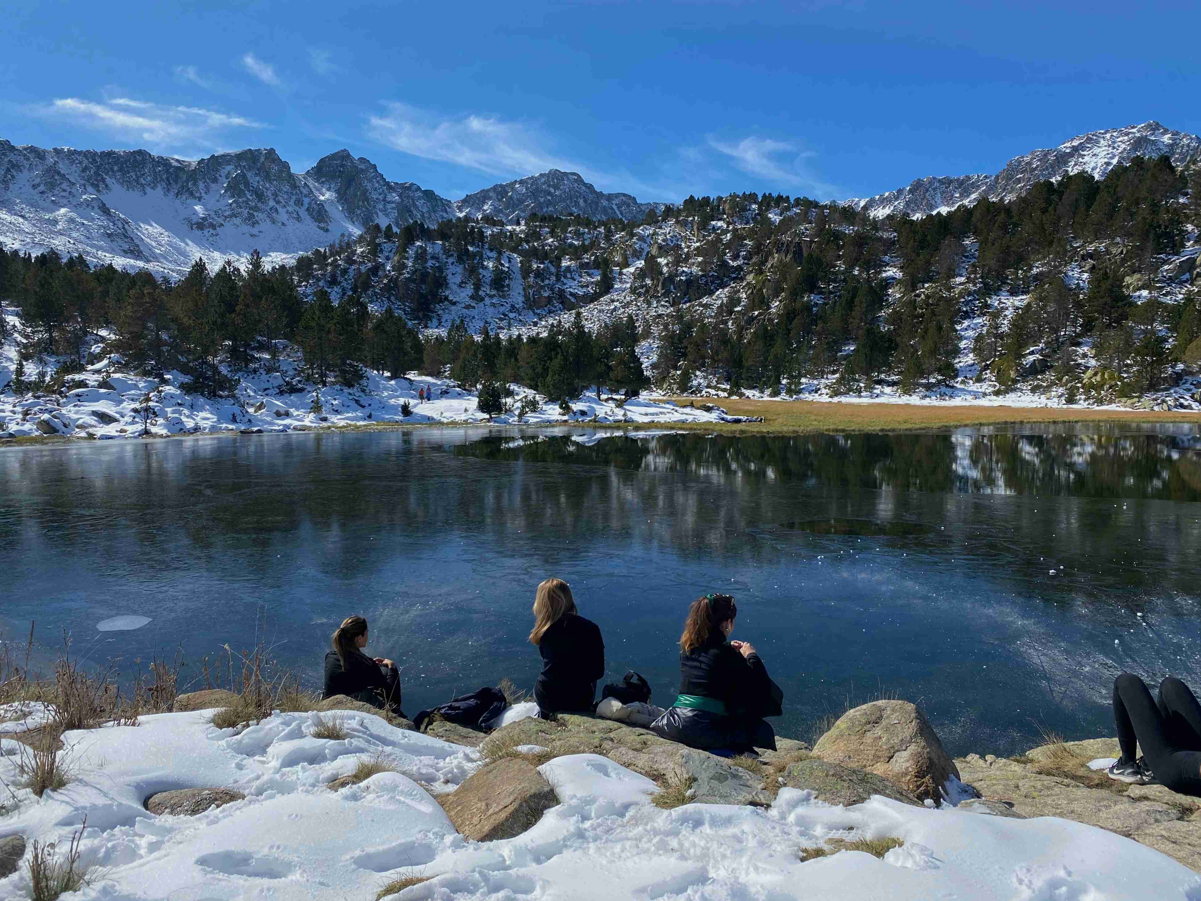 people-sitting-on-rock-near-lake-during-daytime
