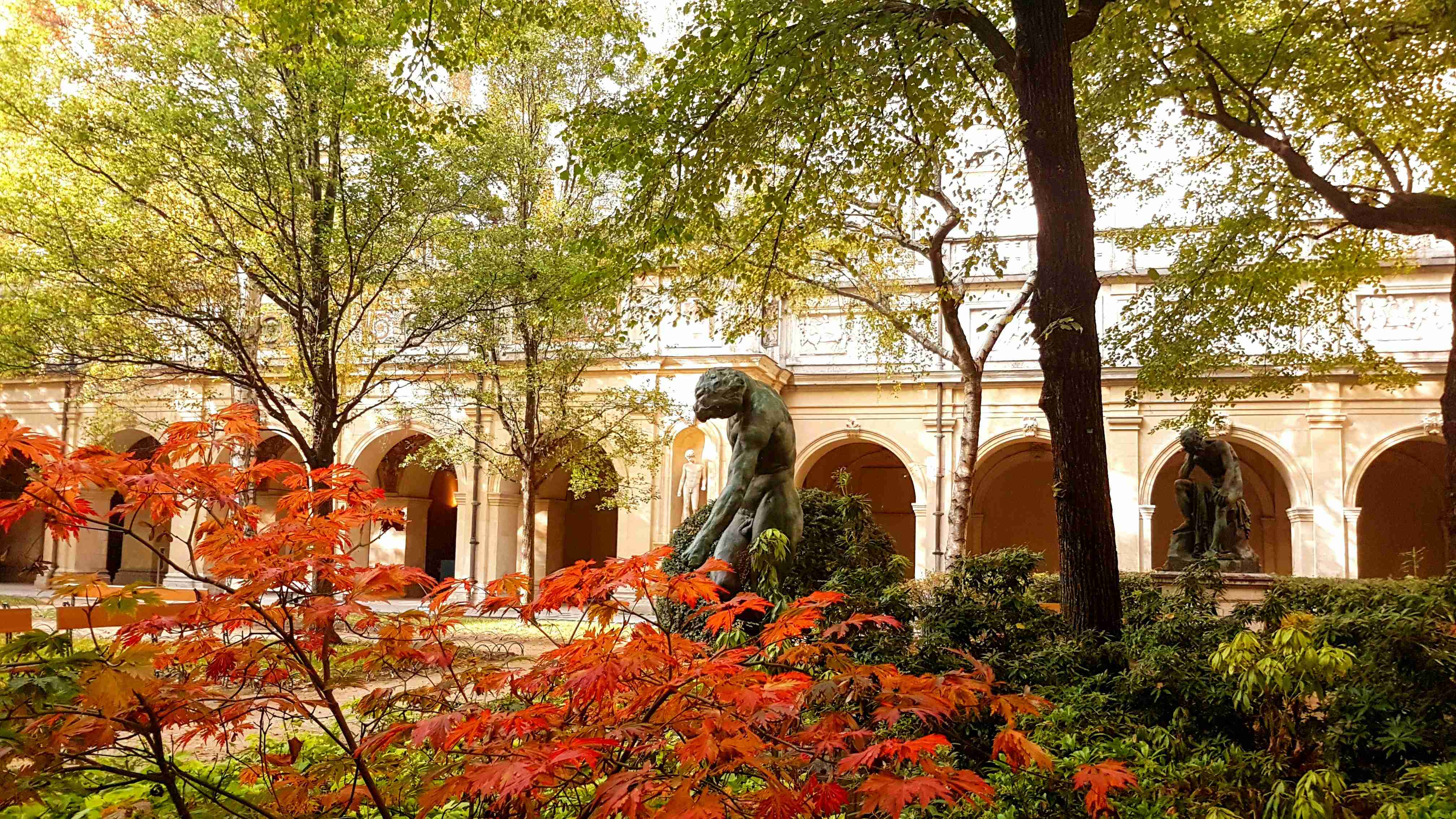 white-concrete-statue-on-orange-and-green-leaves
