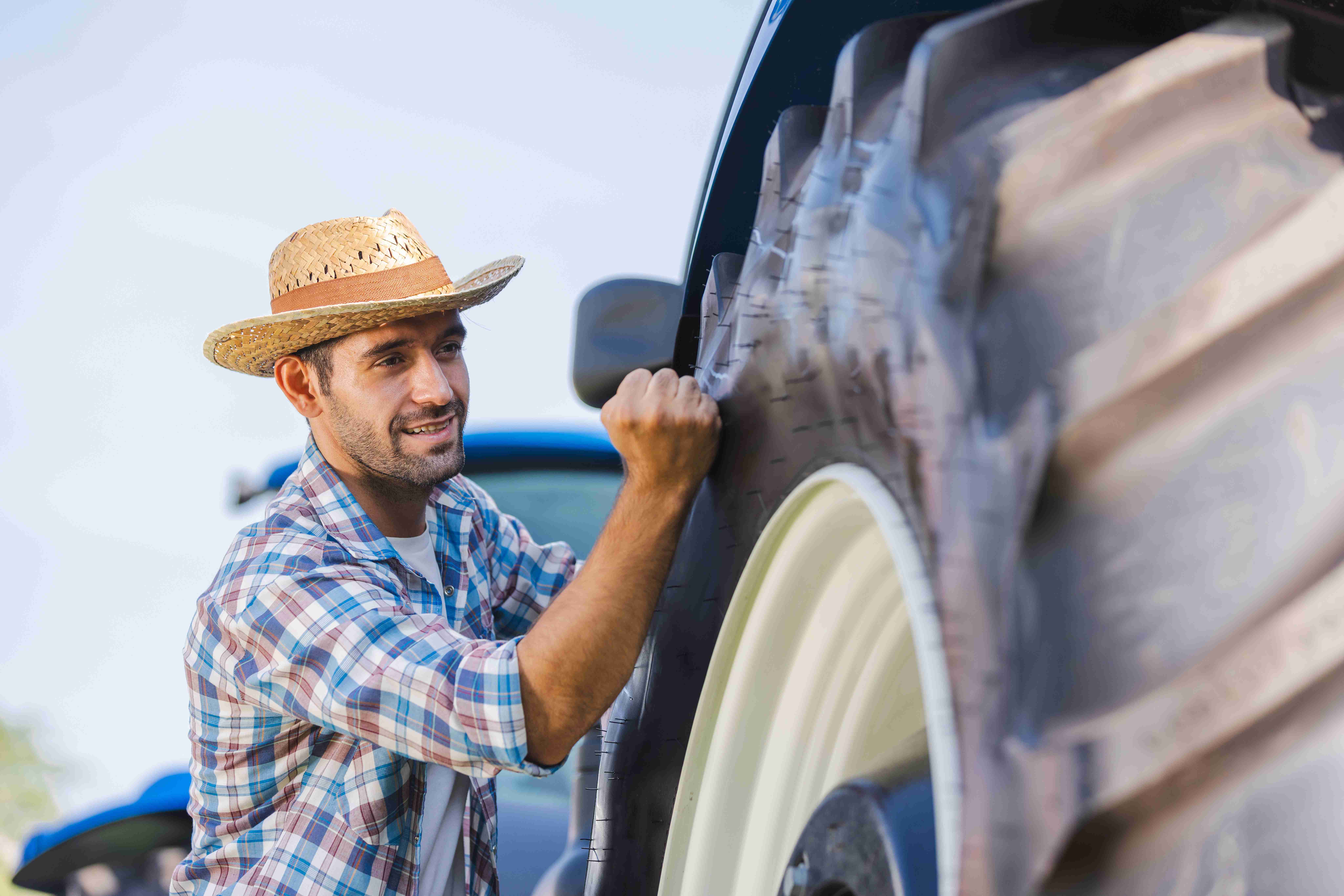 farmer-checks-condition-of-tractor-tires-before