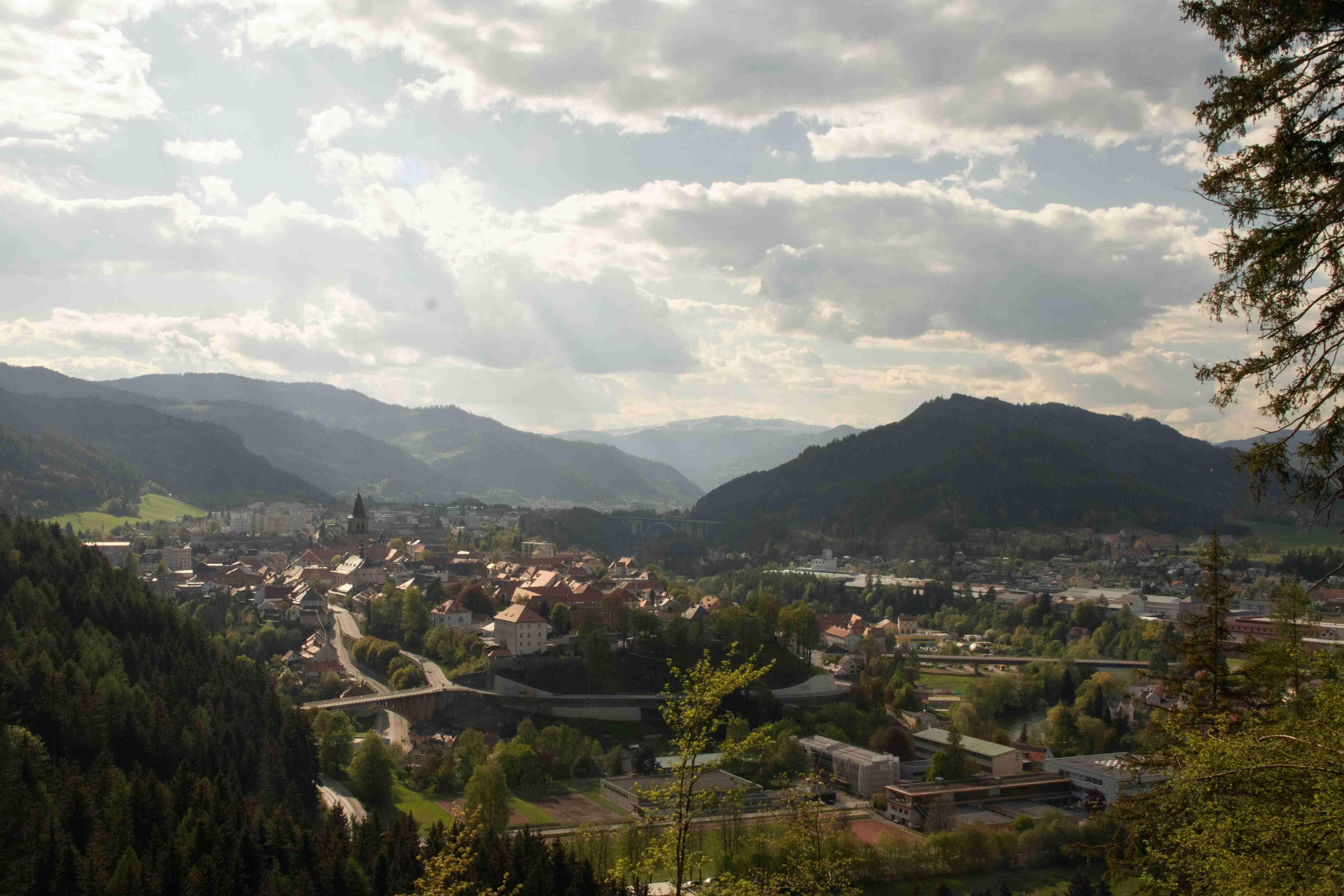 نمایی زیبا از یک شهر کوچک که توسط کوه احاطه شده است