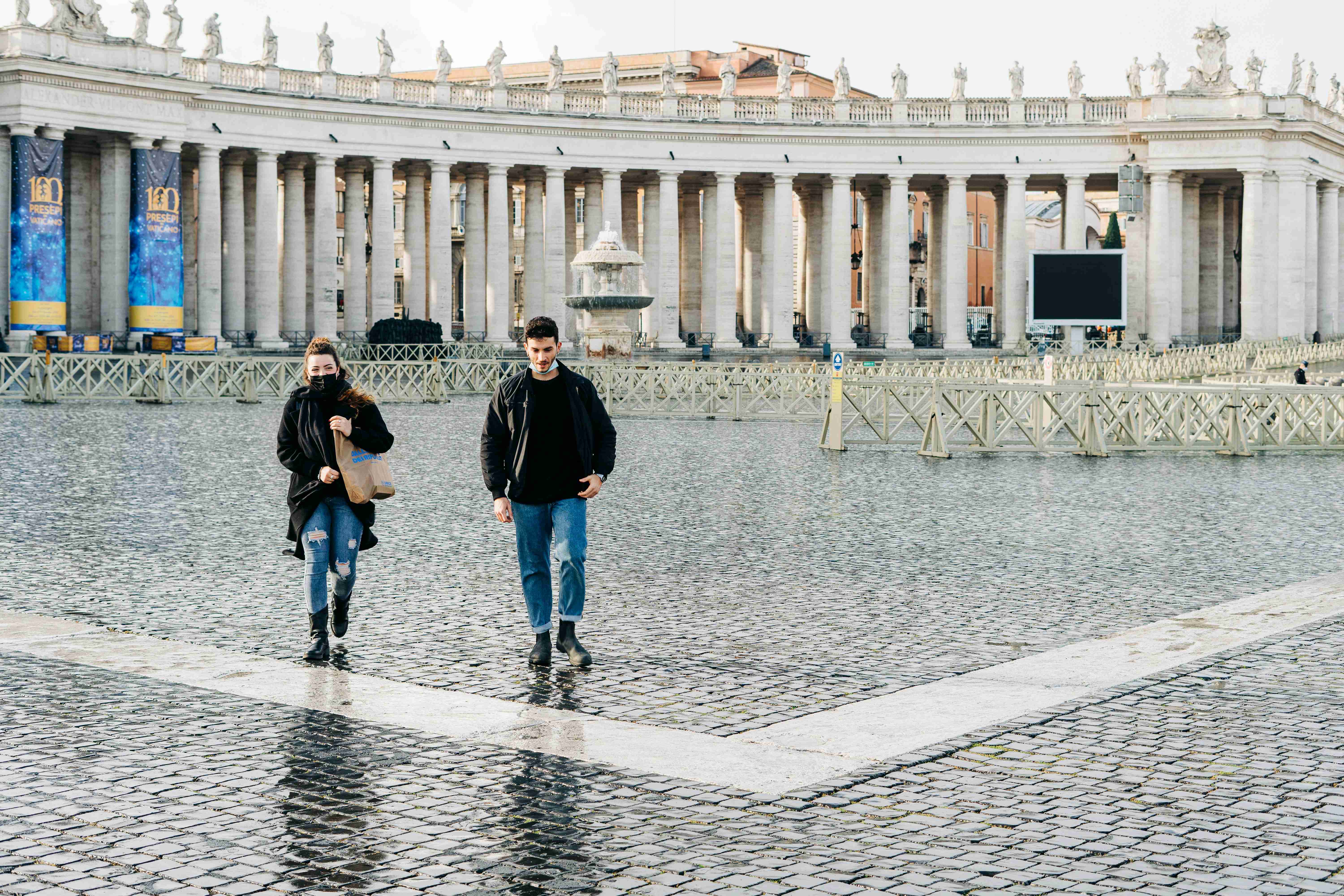 muž a žena kráčející po šedém betonovém chodníku