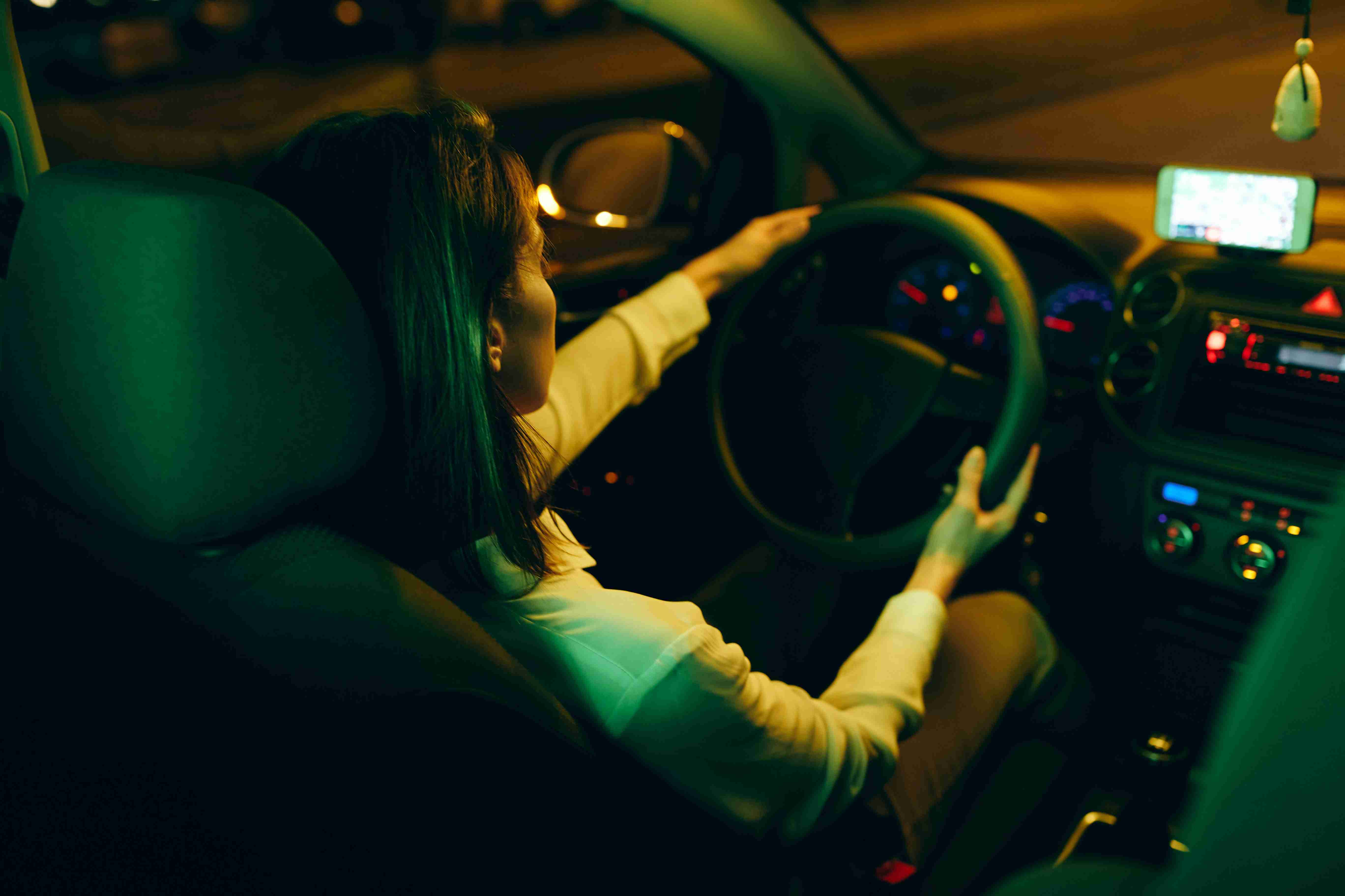 back-view-of-woman-enjoying-in-night-ride-by-her-car