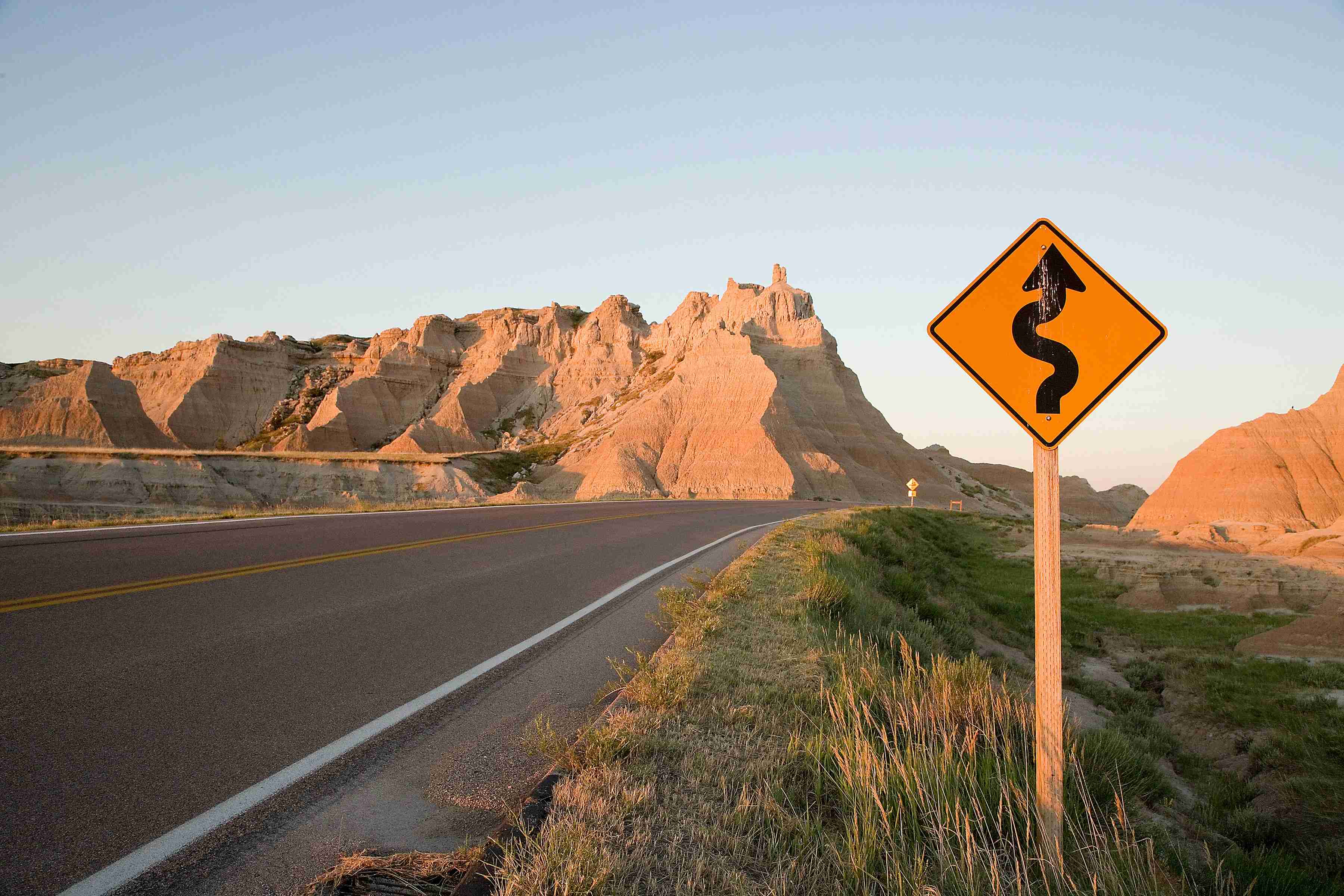 a-yellow-road-sign-sitting-on-the-side-of-a-road