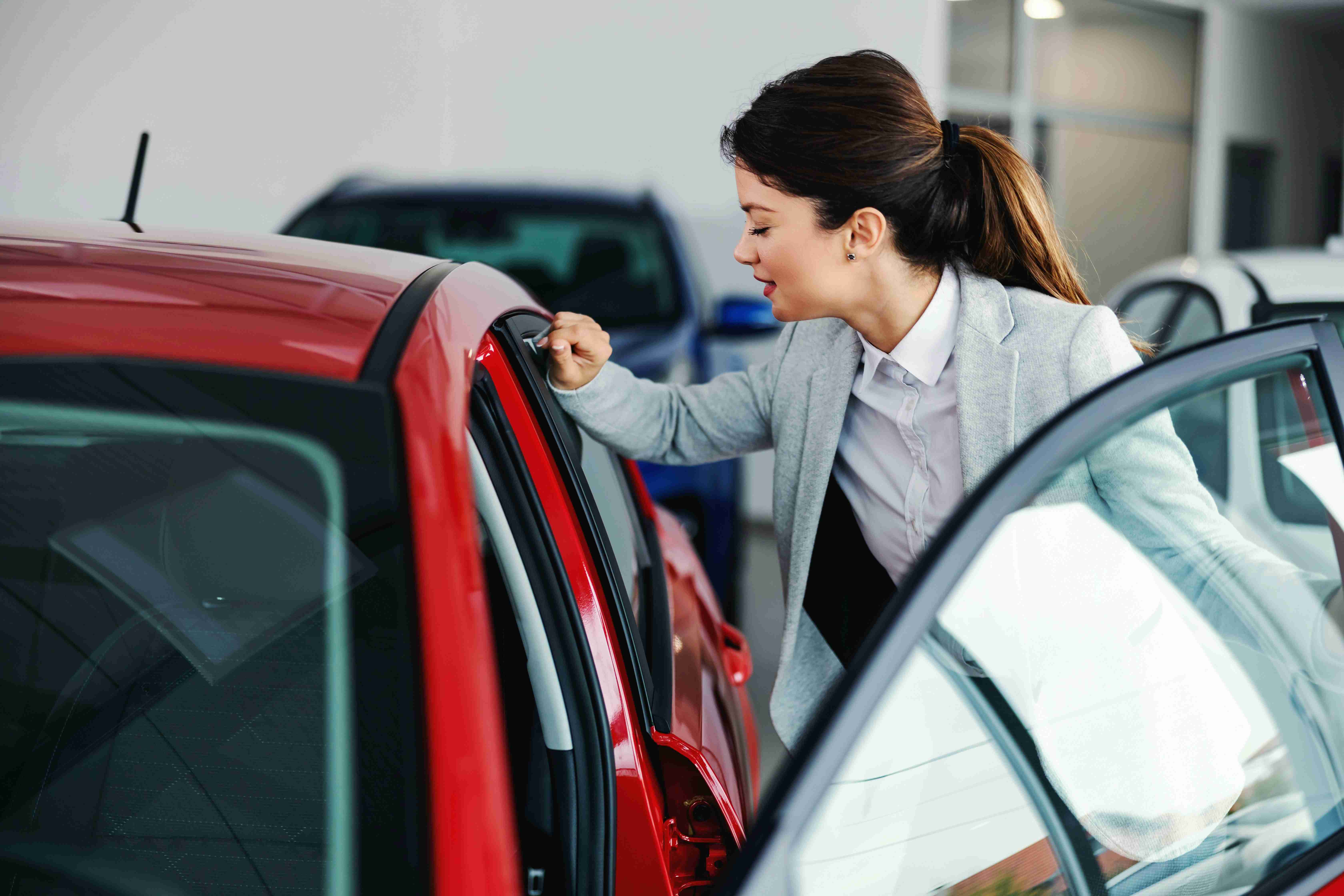 woman-examining-car-dealership
