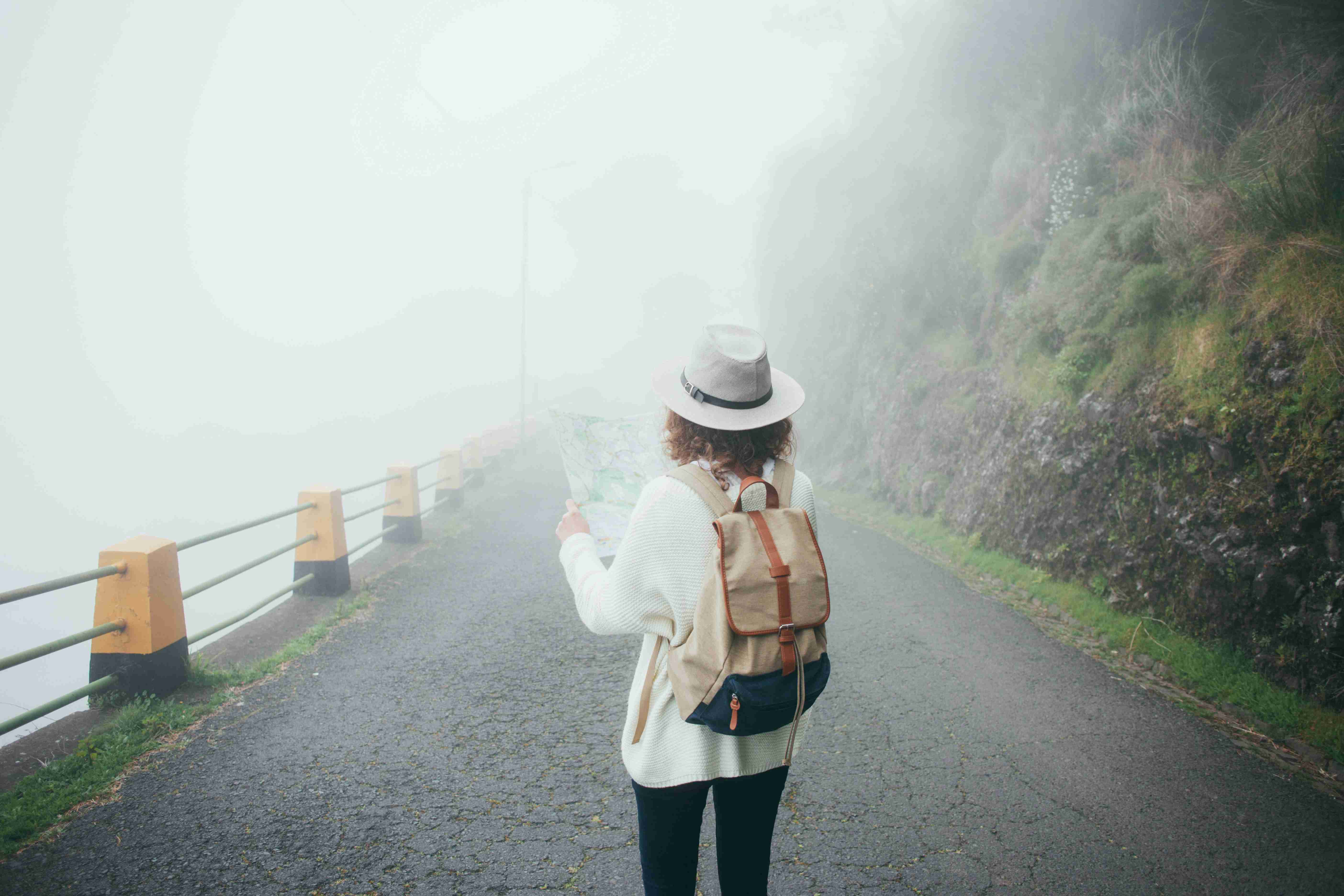 Traveler with Backpack Navigating in Foggy Weather