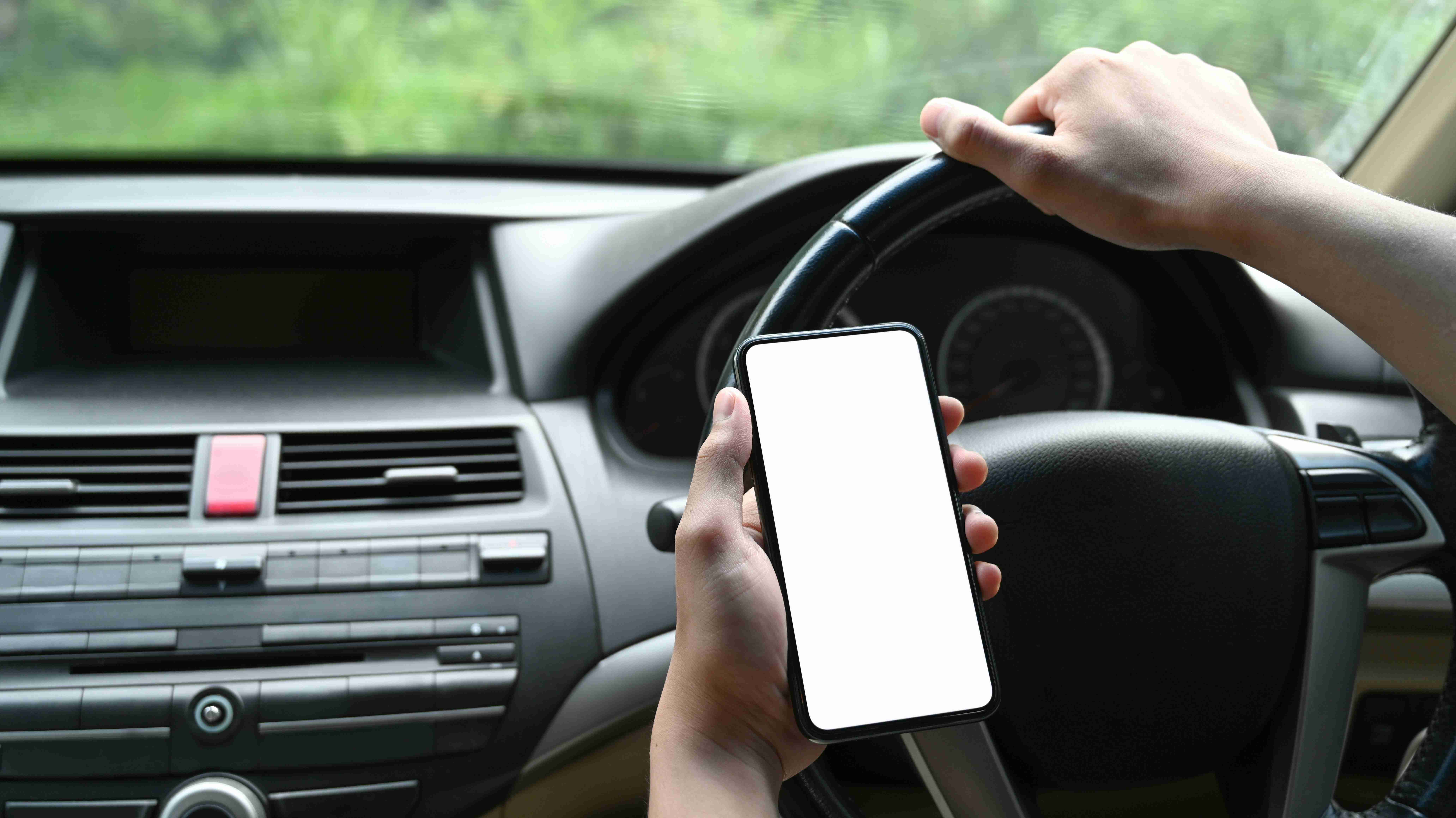 close-up-view-of-young-man-using-smart-phone-while-driving-car