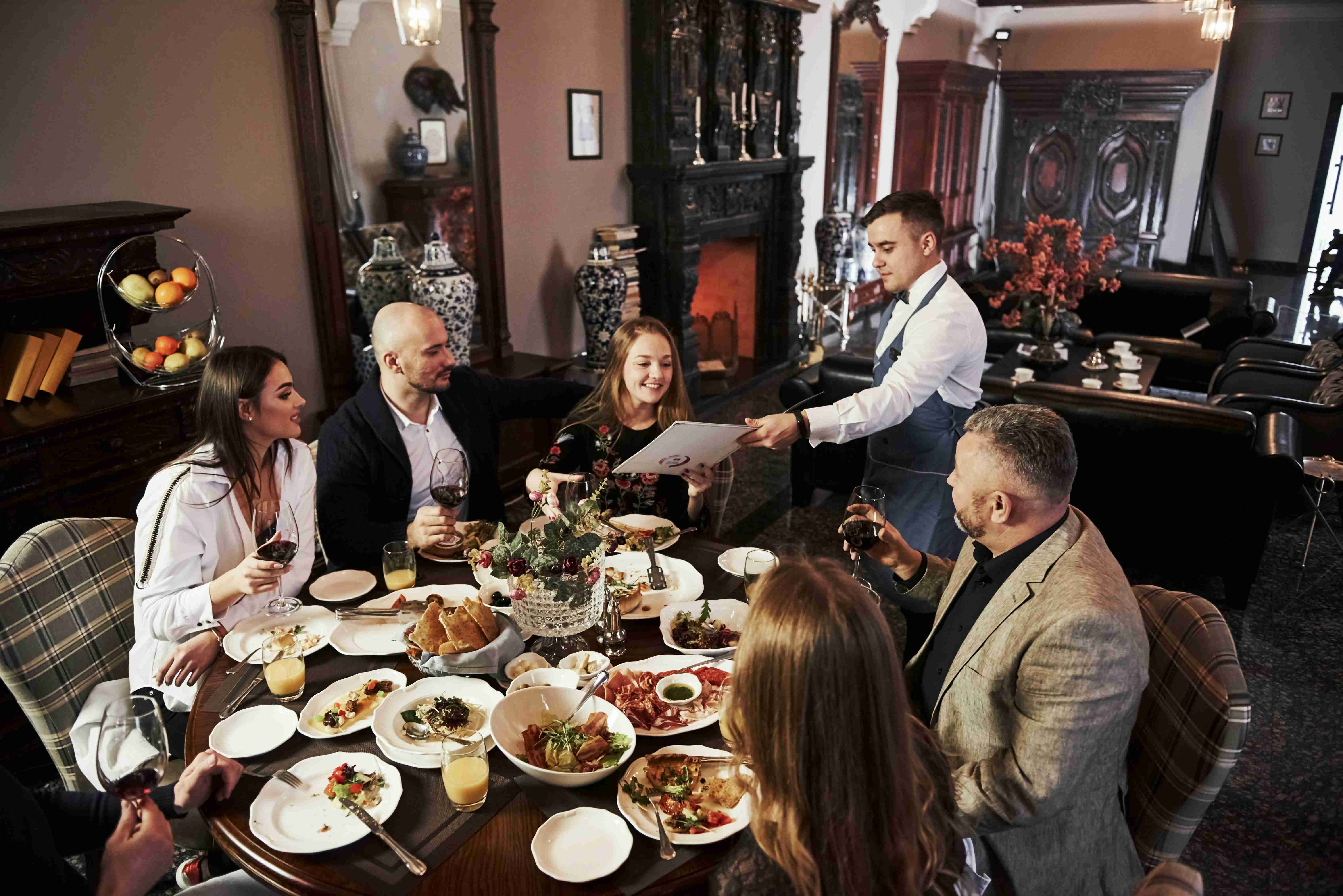 heres-our-menu-family-friends-having-nice-time-in-beautiful-luxury-modern-restaurant