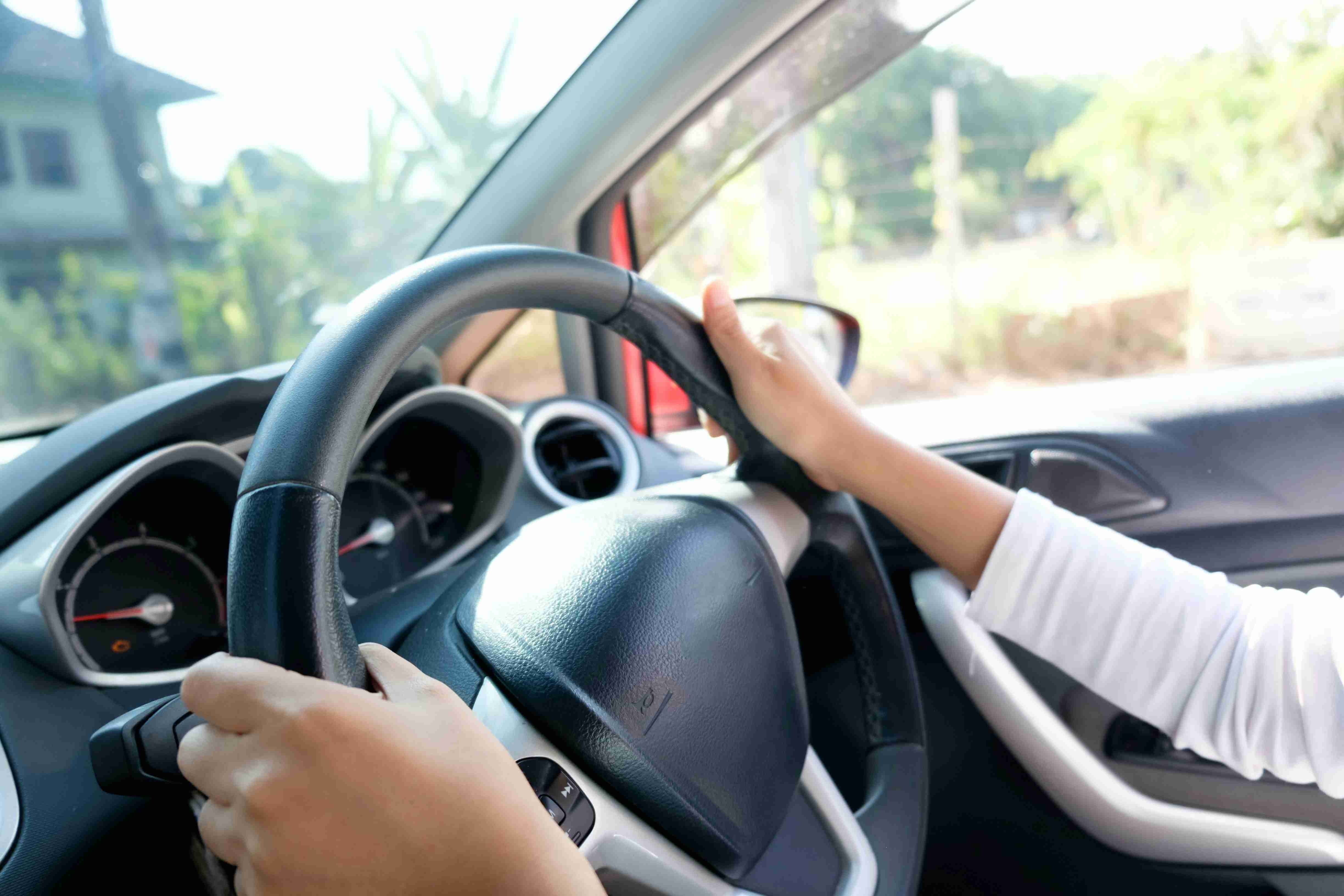 cropped shot of woman hands driver with driving a car