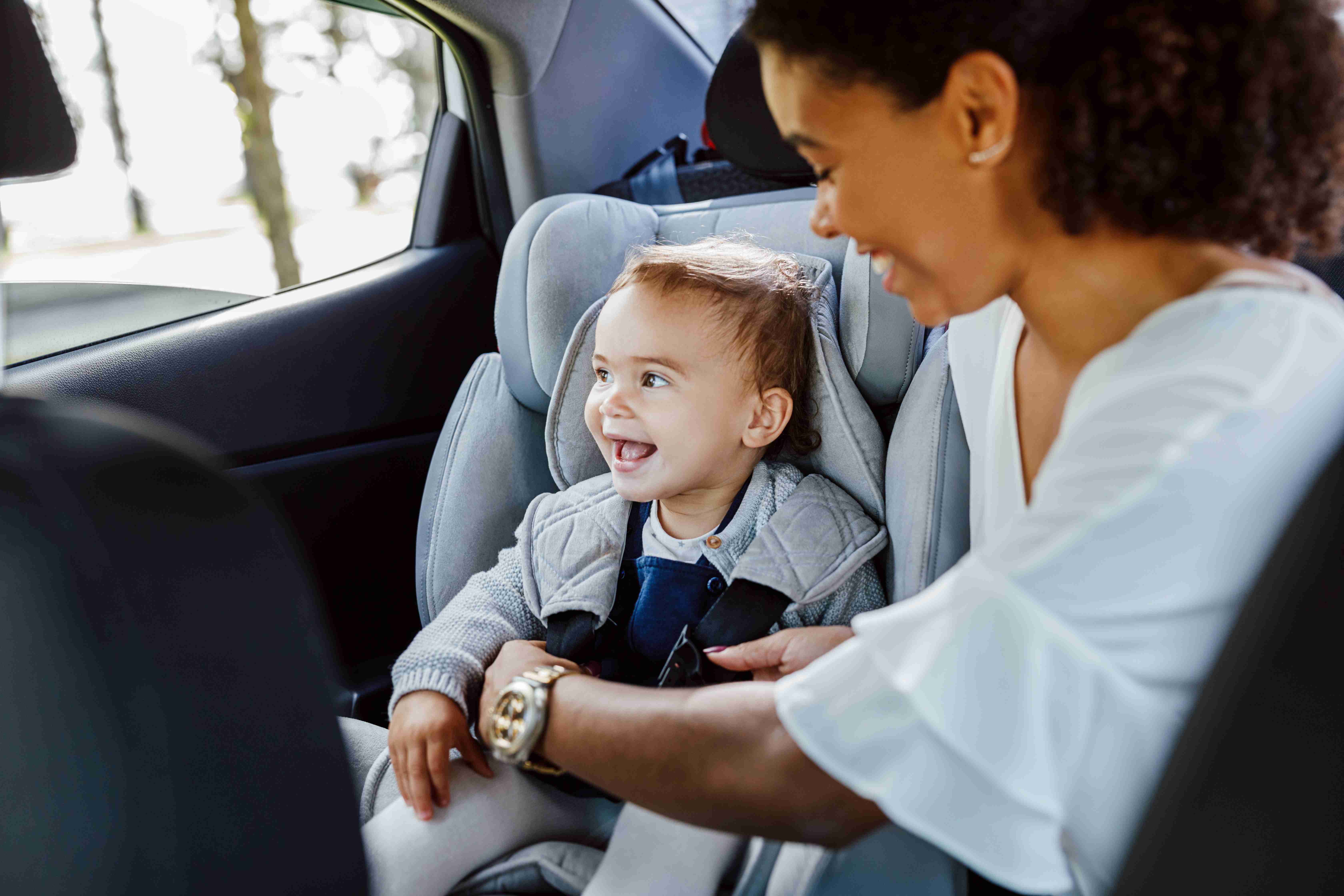 Gadis kecil gembira duduk di tempat duduk belakang
