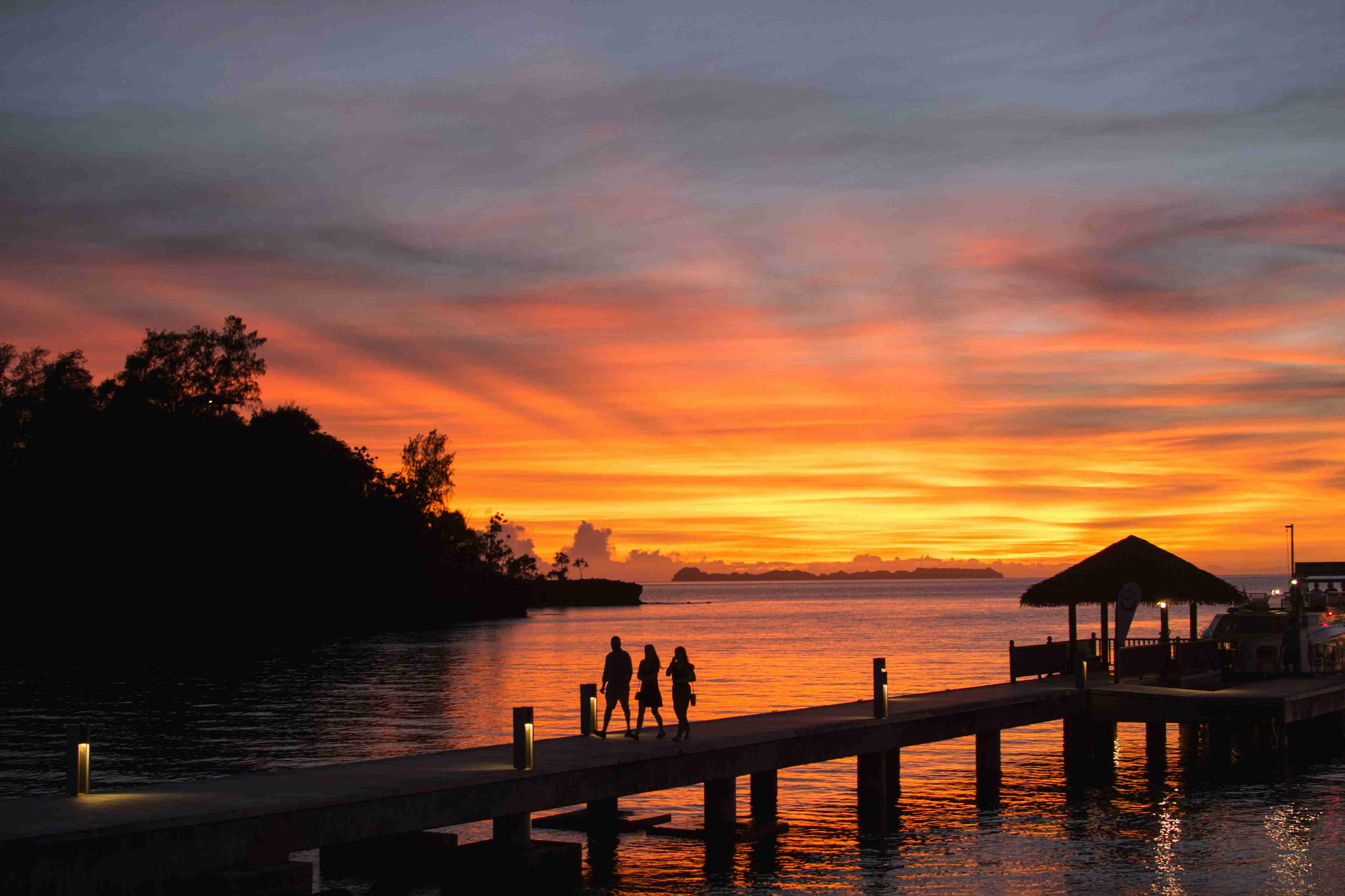 група-людей-стоїть-на-док-у-захід-сонця
