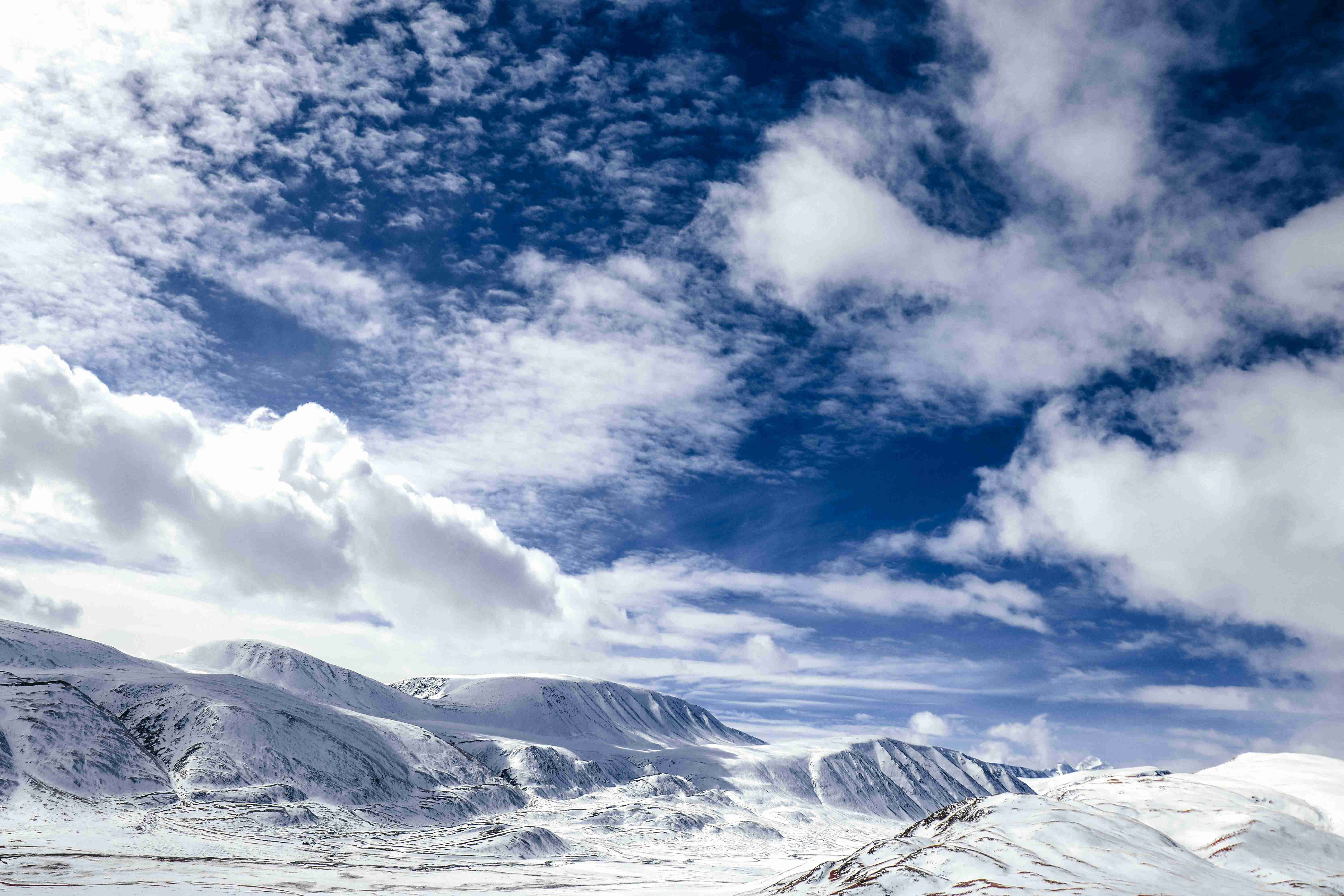 snow covered mountain under white clouds